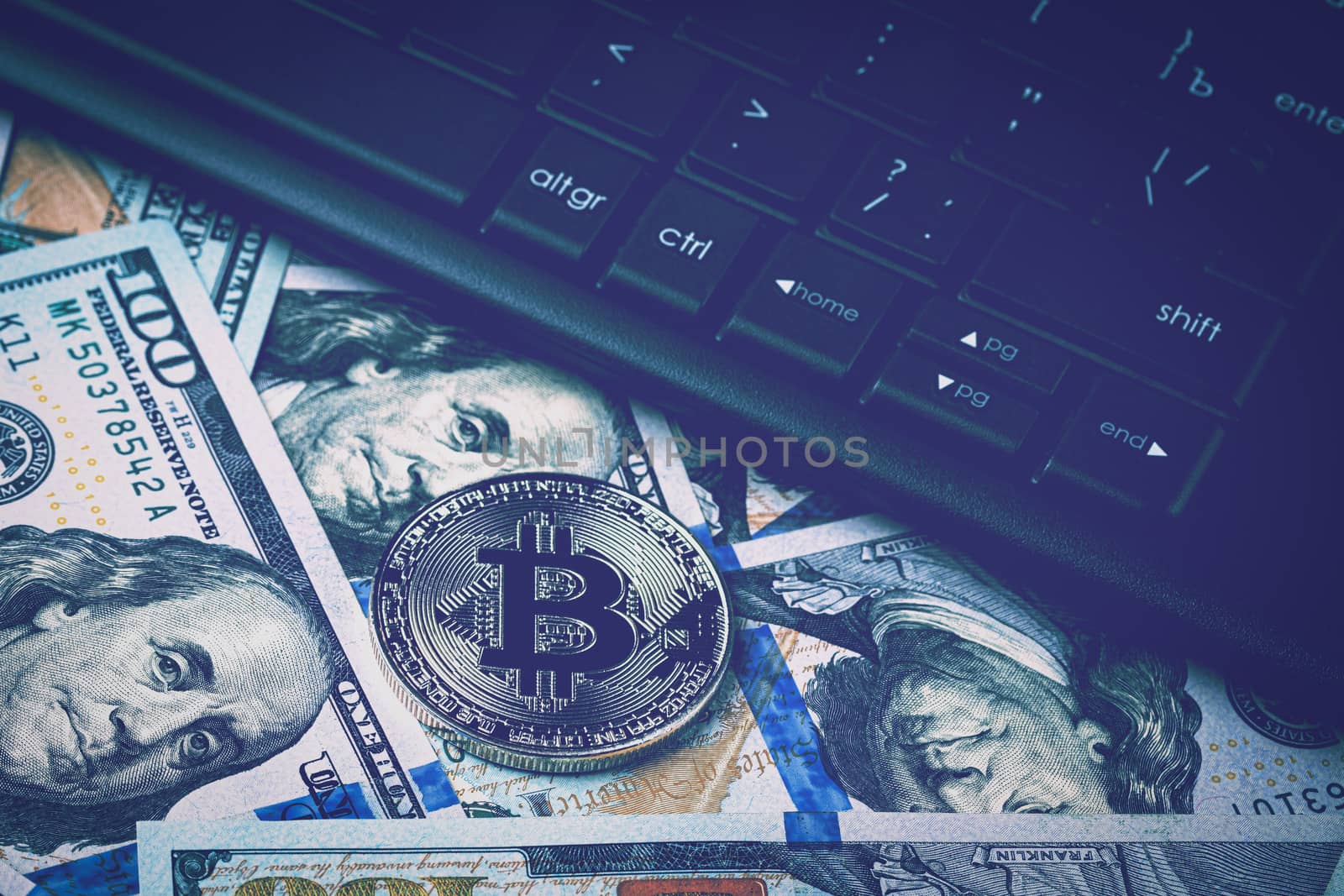 Dollar bills, black keyword and metal souvenir bitcoin. The concept of electronic money, online trading, mining and commerce. Cryptocurrency and cash.