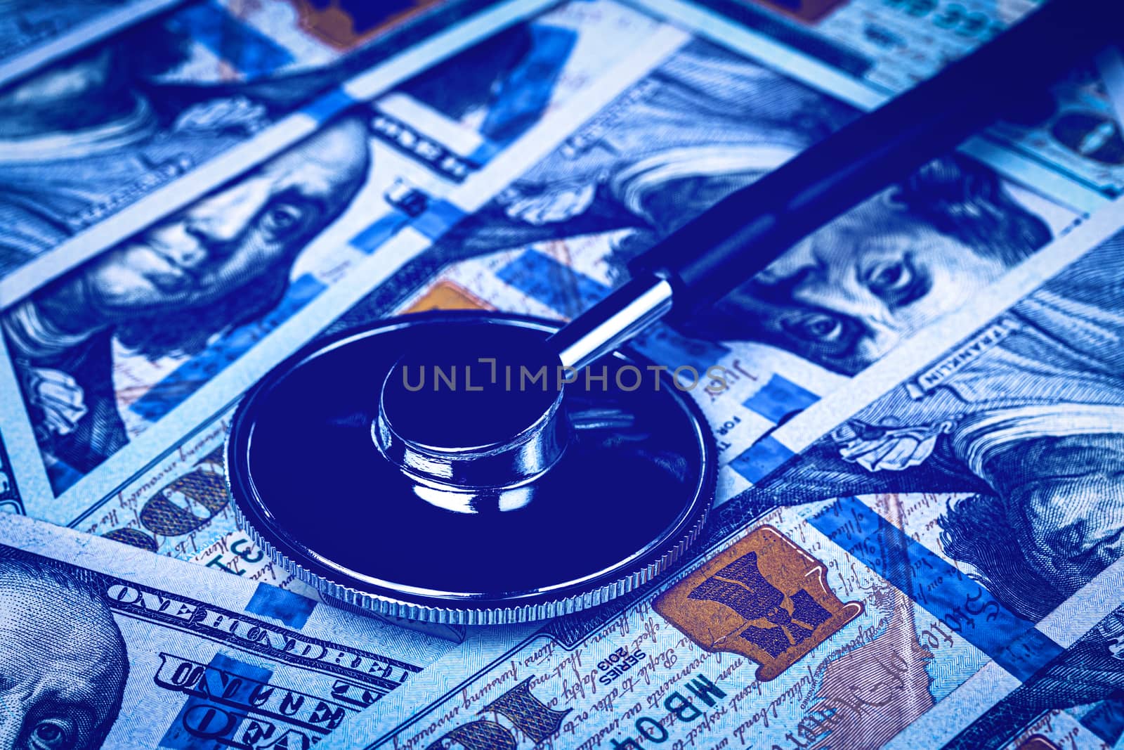 Stethoscope on the background of one hundred dollar bills. The concept of the expensive cost of healthcare or financing medicine.