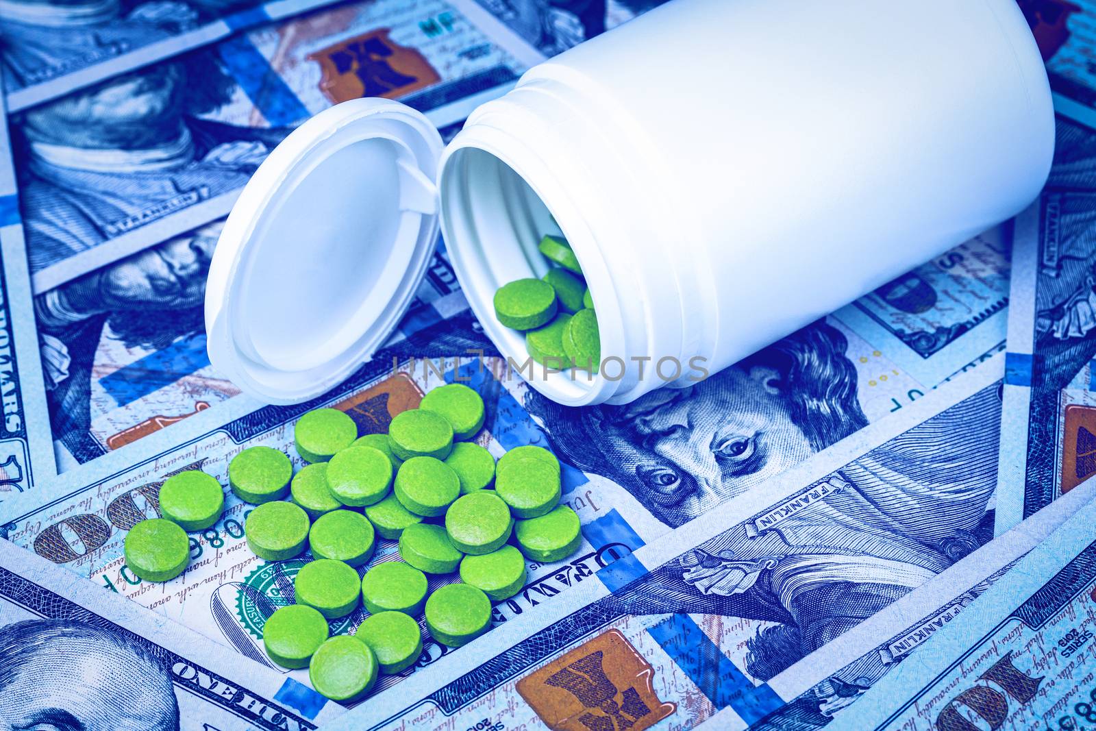 Green pills on the background of one hundred dollar bills. The c by Eugene_Yemelyanov