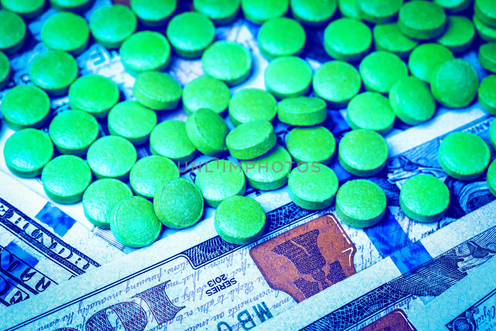 Green pills on the background of one hundred dollar bills. The c by Eugene_Yemelyanov