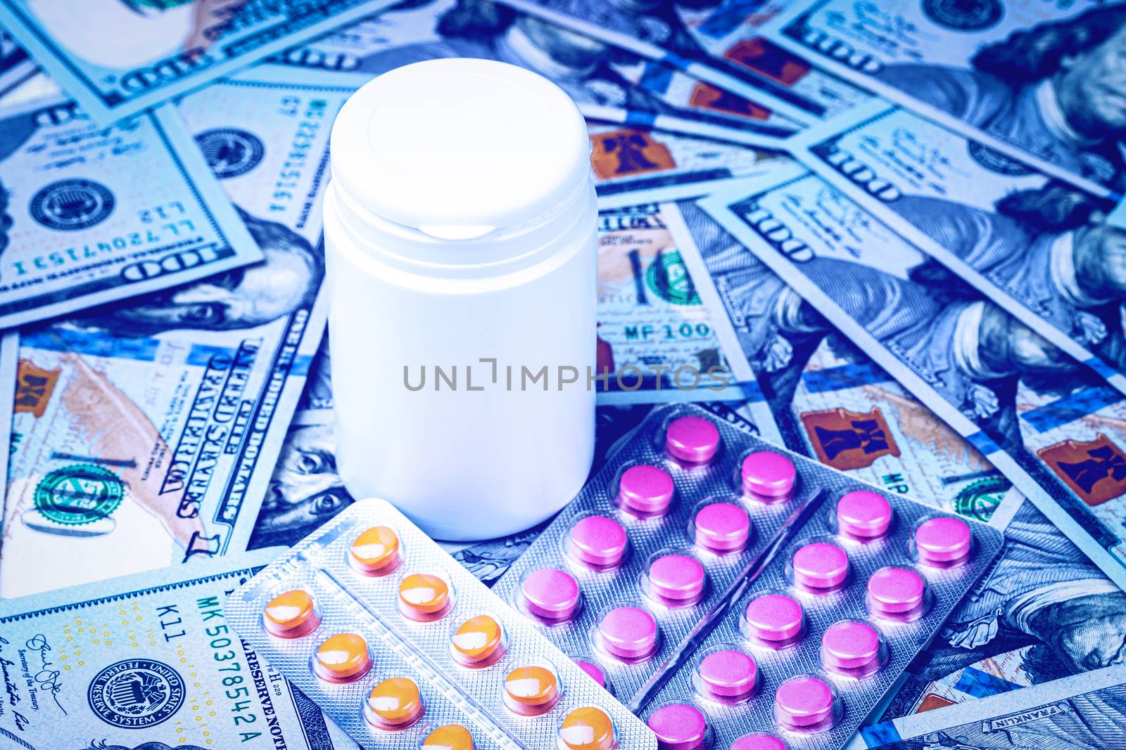 Plate with pills in the shape of a heart on the background of hundred-dollar bills. The concept of the expensive cost of healthcare or financing medicine. White medicine bottle with copy space for text.