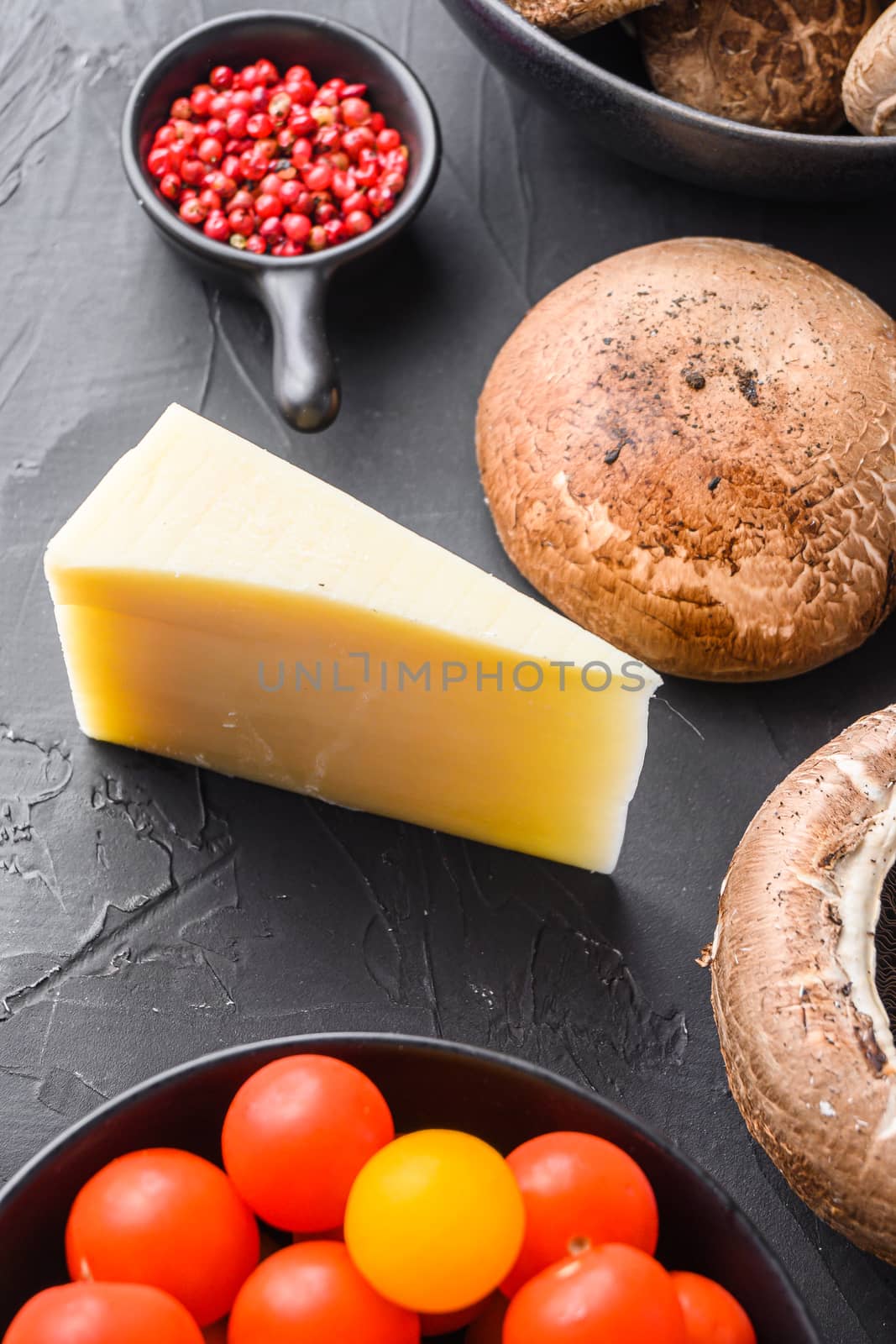 Cheddar cheese and portabello mushrooms ingredients for baking, and sage on black background.top view close up. by Ilianesolenyi