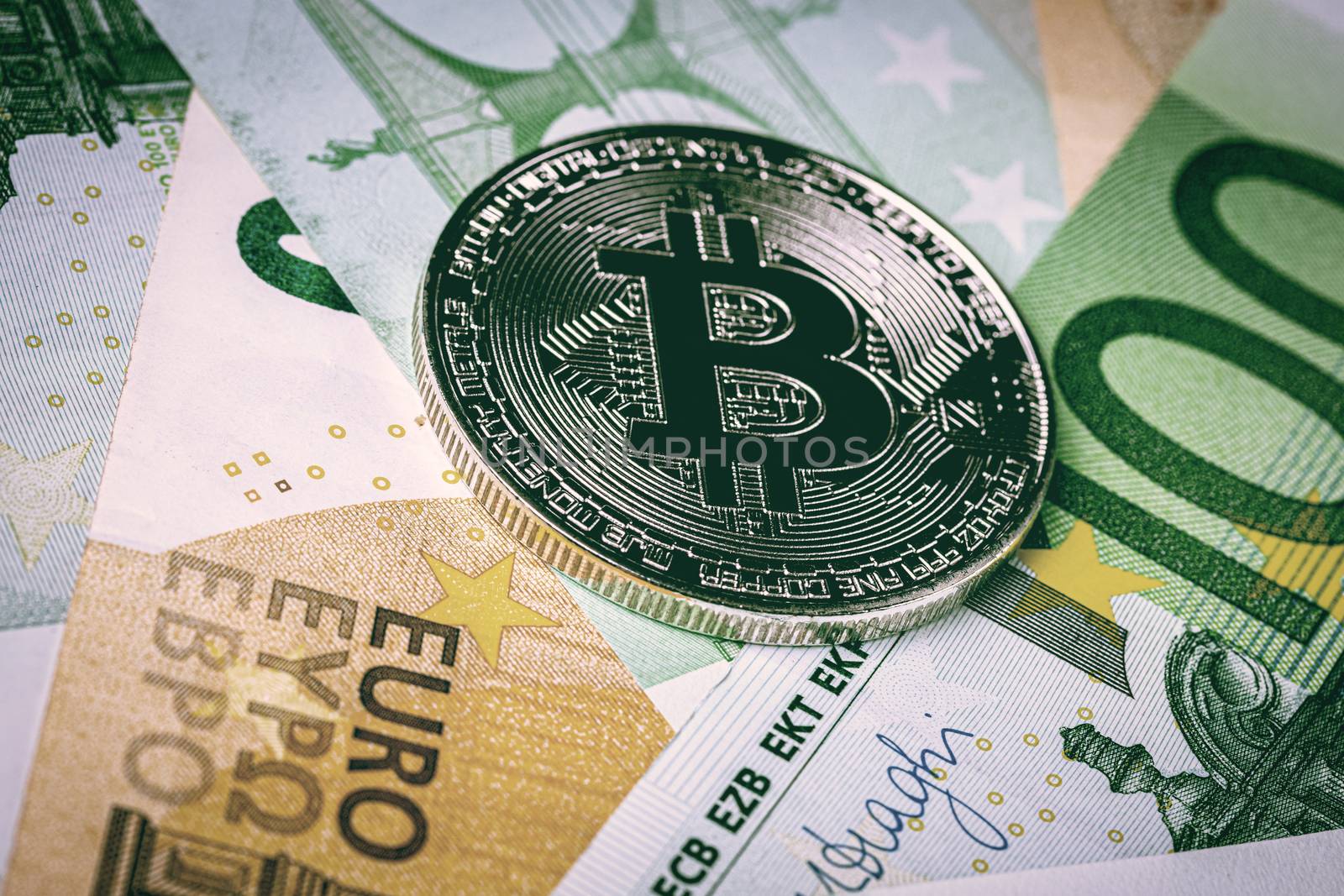 Euro bills and metal souvenir bitcoin. The concept of electronic by Eugene_Yemelyanov