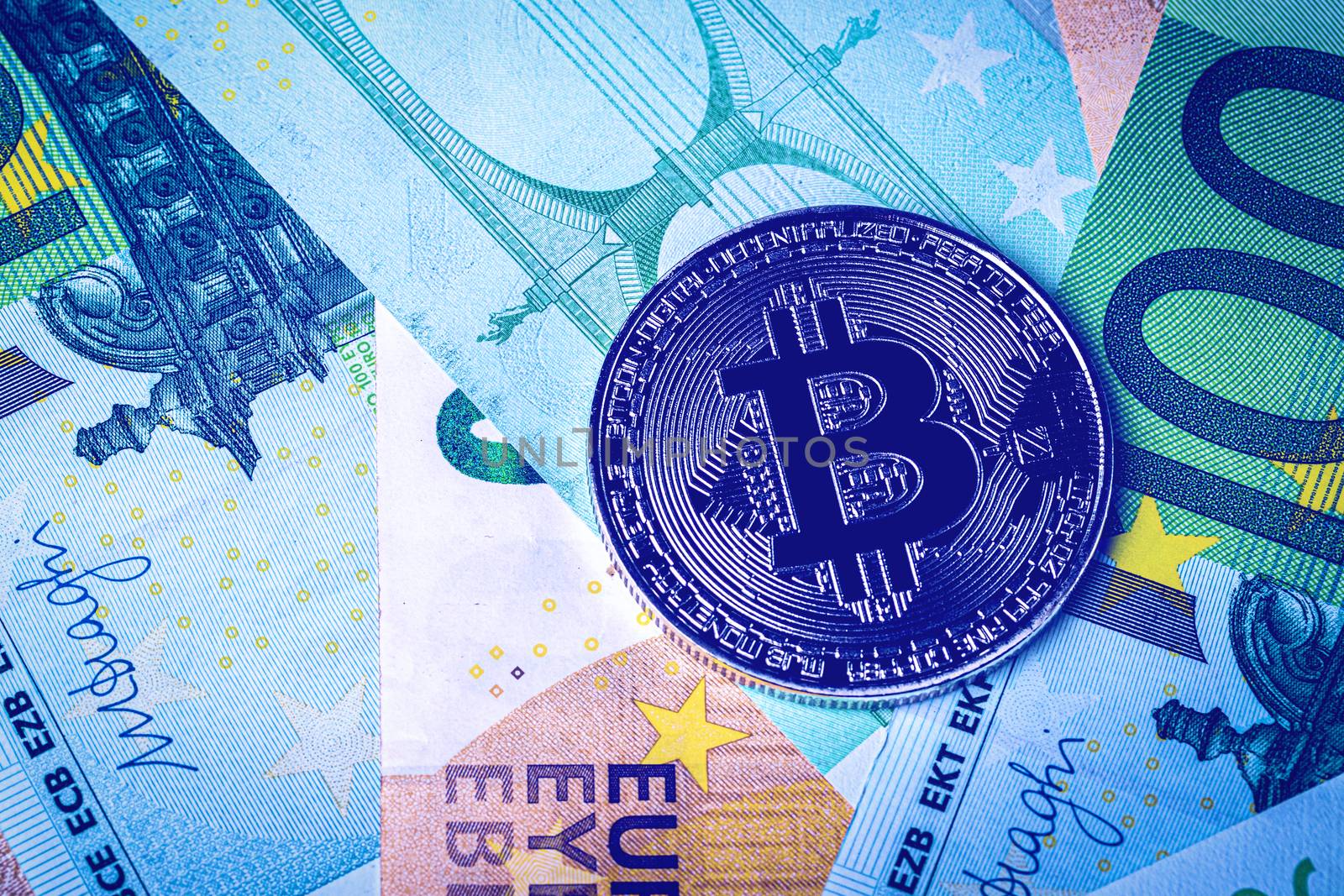 Euro bills and metal souvenir bitcoin. The concept of electronic money and commerce. Cryptocurrency and cash.