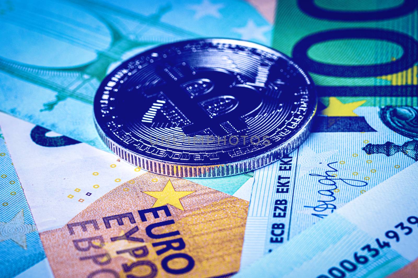 Euro bills and metal souvenir bitcoin. The concept of electronic money and commerce. Cryptocurrency and cash.