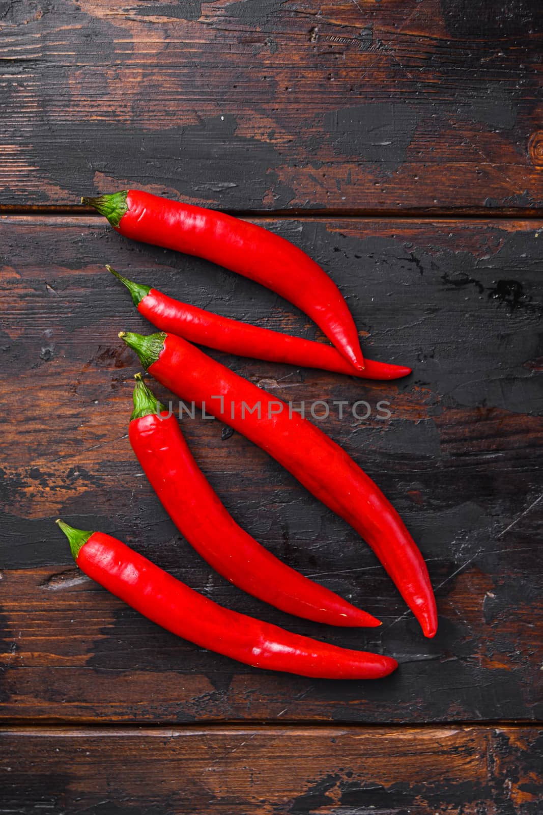 Red Hot Chili Peppers over old dark wooden table top view. High quality.