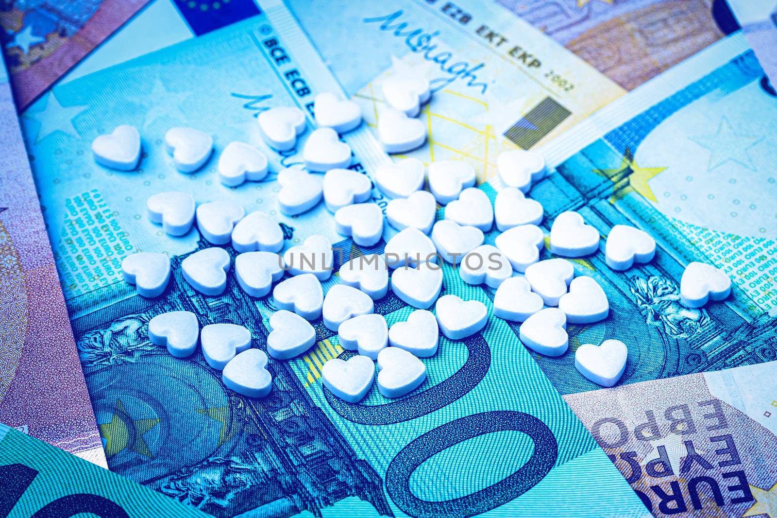 Heart-shape pills on the background of euro bills. The concept o by Eugene_Yemelyanov