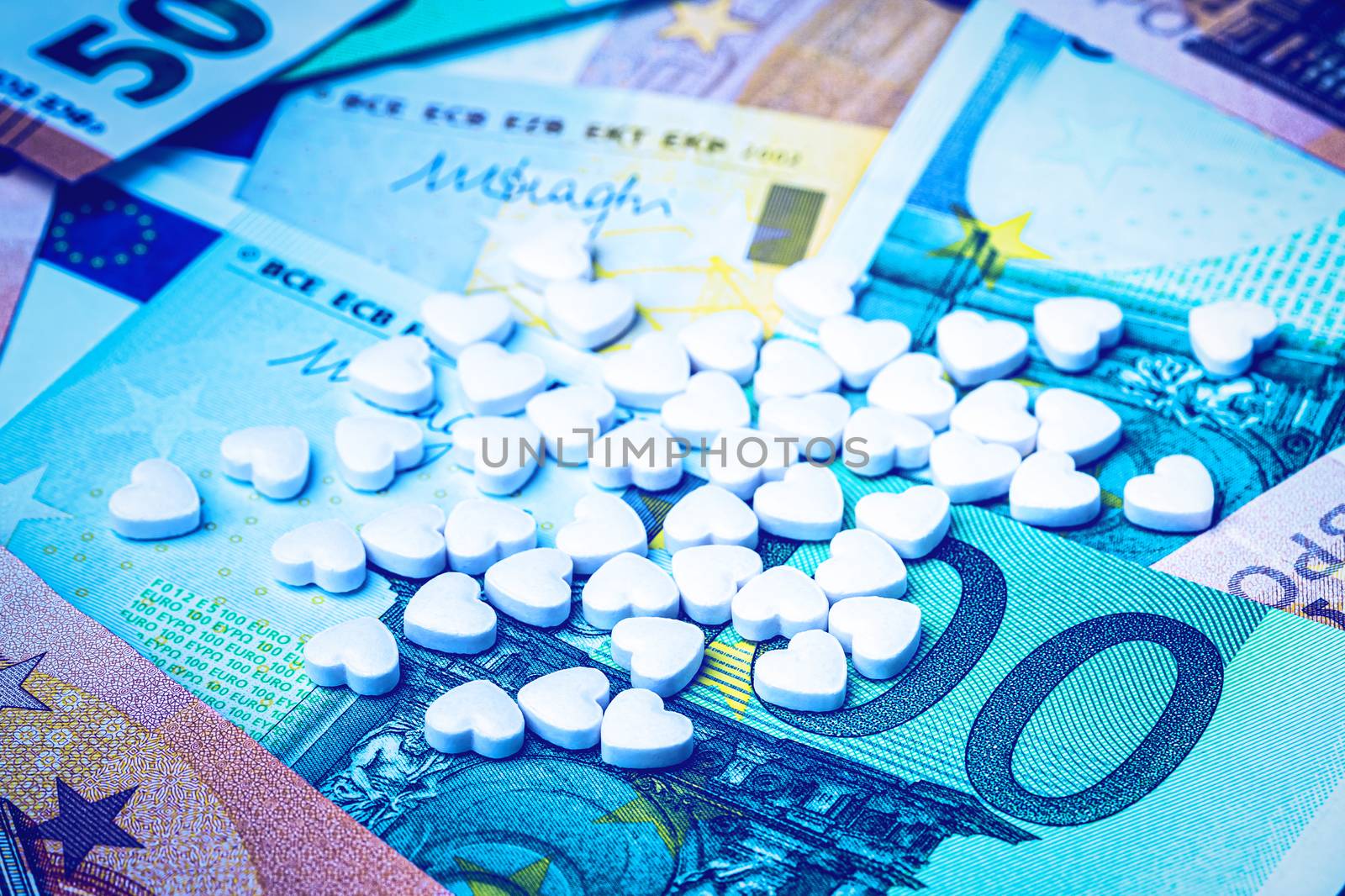 Heart-shape pills on the background of euro bills. The concept of the expensive cost of healthcare or financing medicine.
