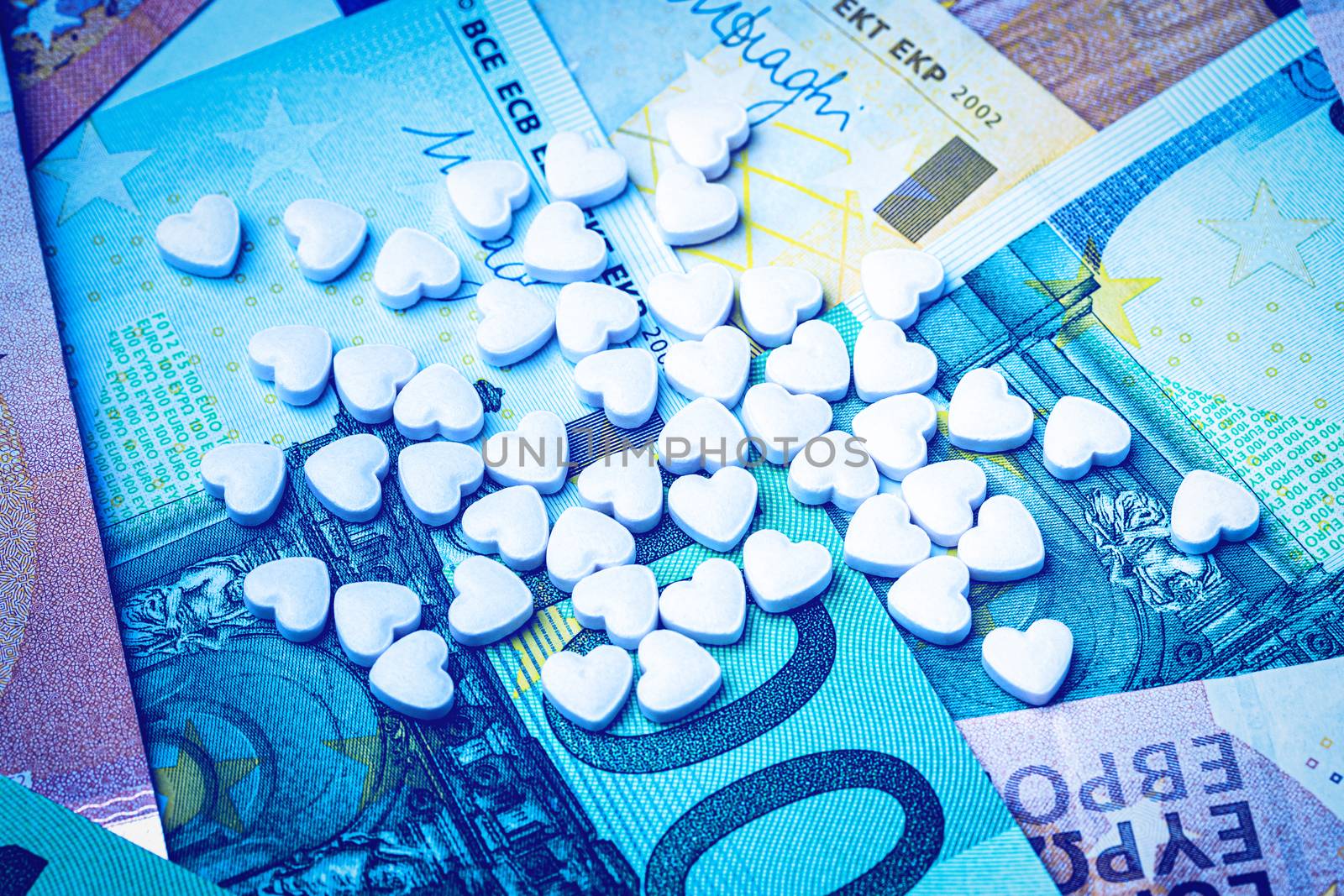 Heart-shape pills on the background of euro bills. The concept o by Eugene_Yemelyanov