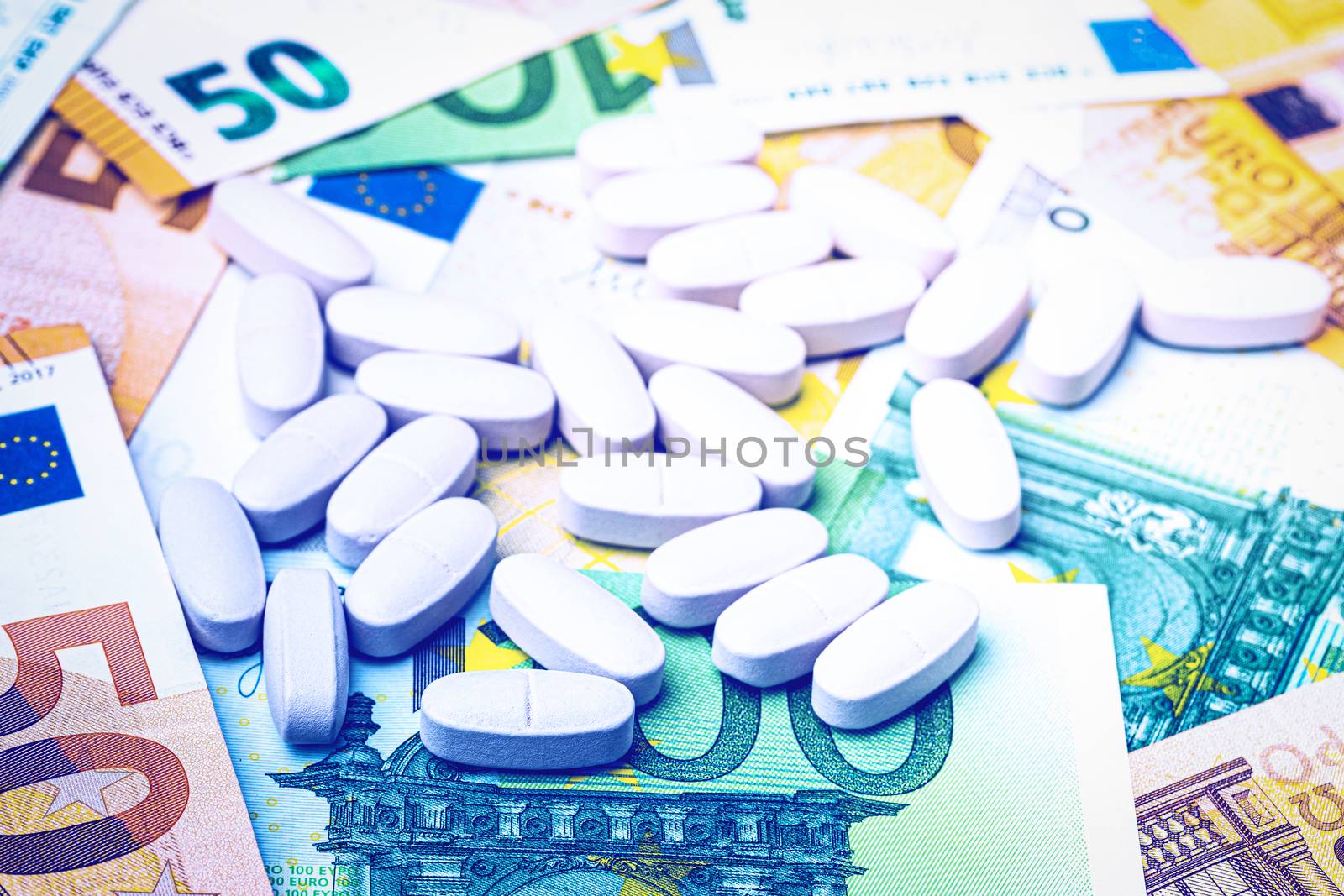 White pills on the background of euro bills. The concept of the expensive cost of healthcare or financing medicine.