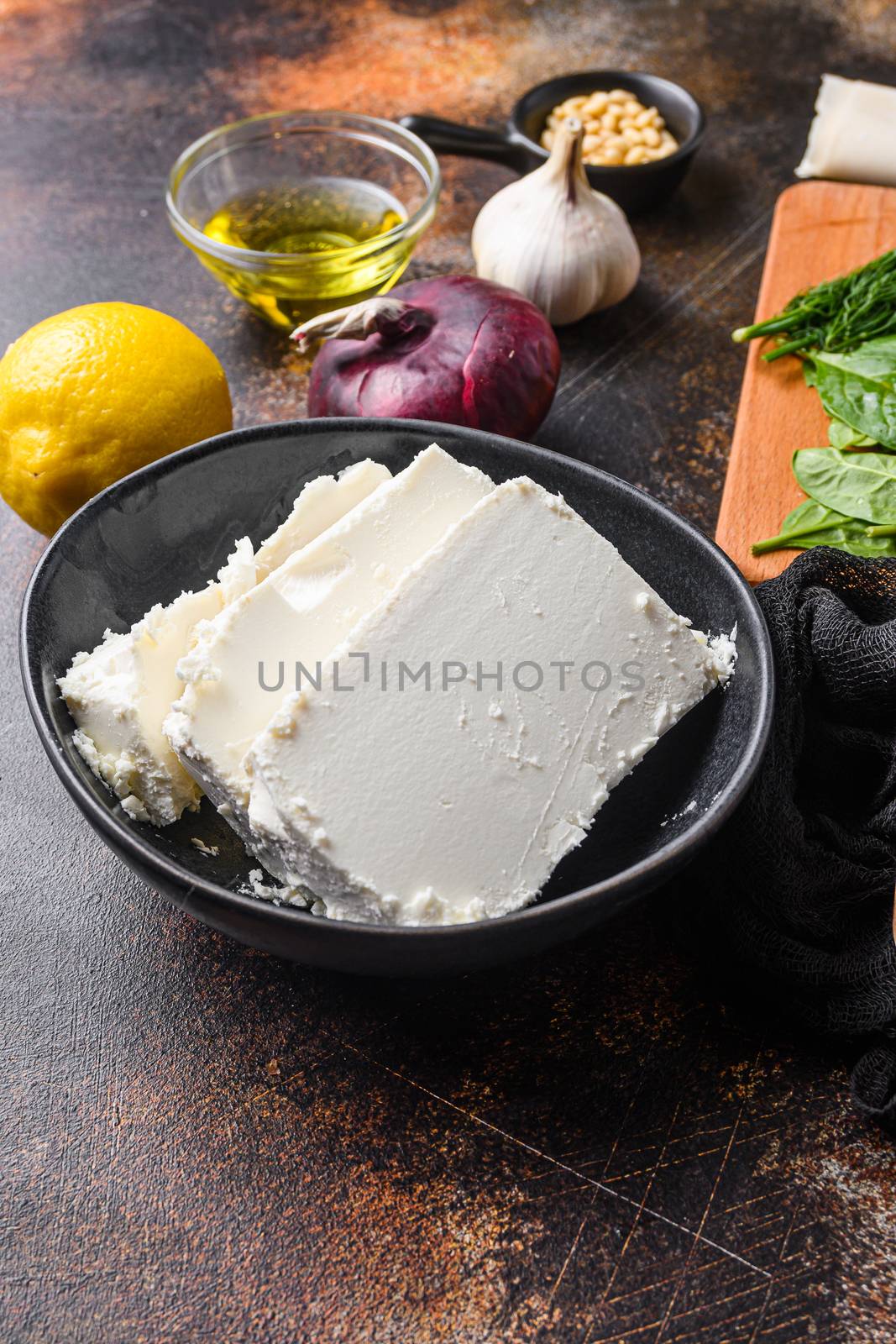 Traditional feta cheese in black bowl side view. by Ilianesolenyi