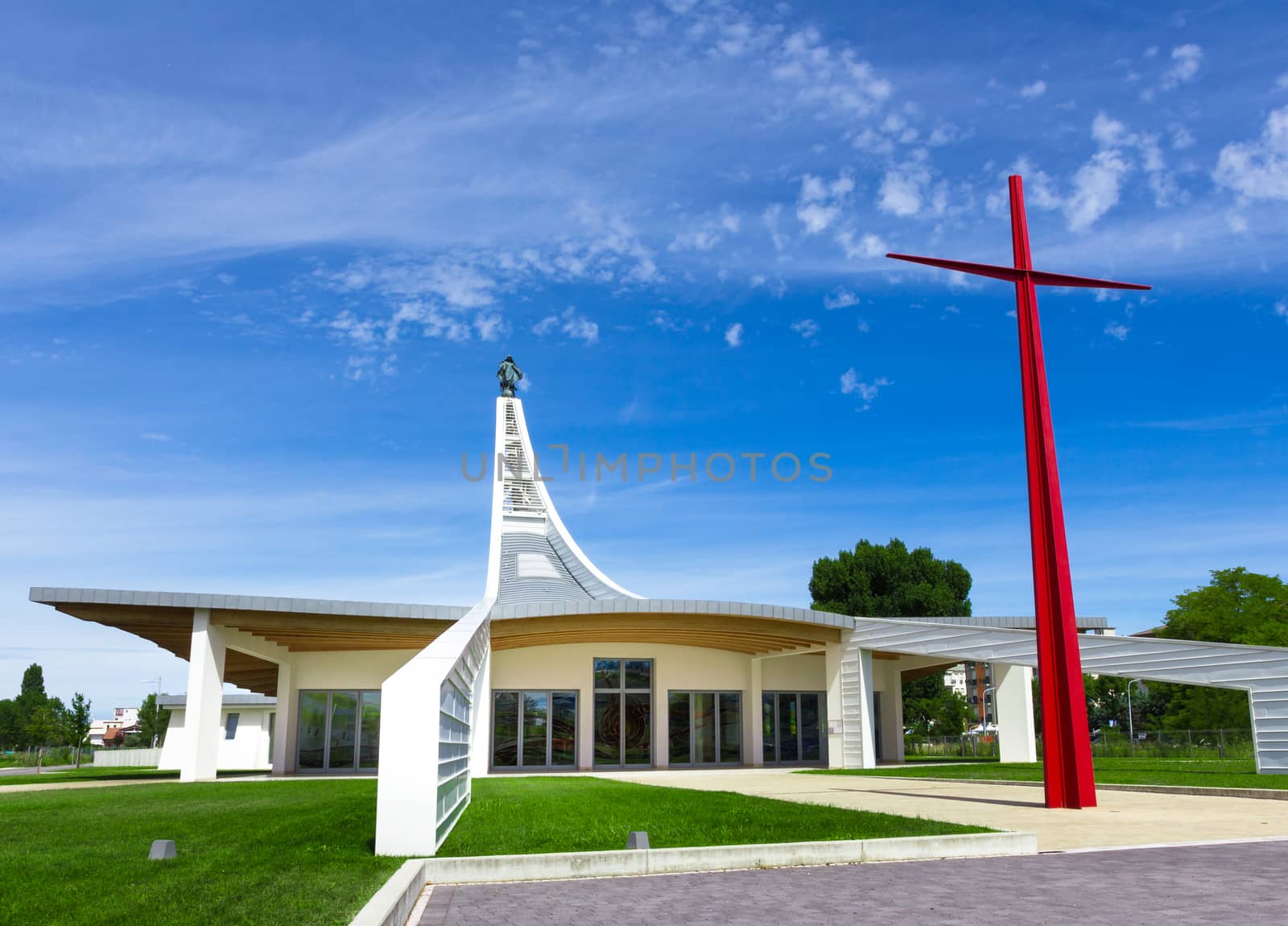 Architecture of a modern church with gray sky with big iron cross