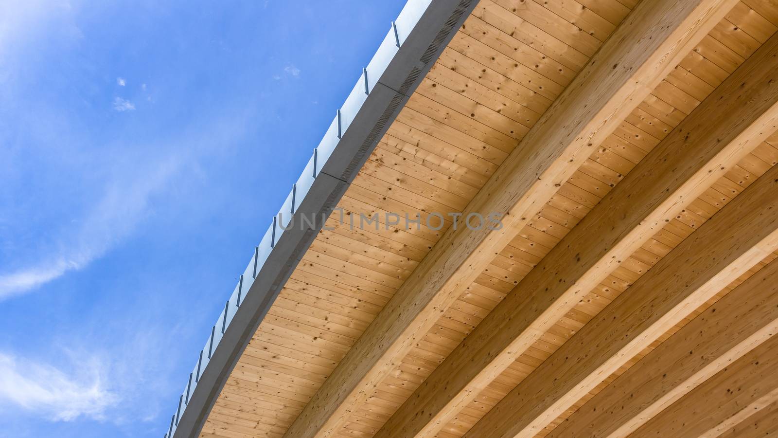 Roof of an ecologically clean wooden house against a beautiful cloudy blue sky. Bottom view. Space for text.