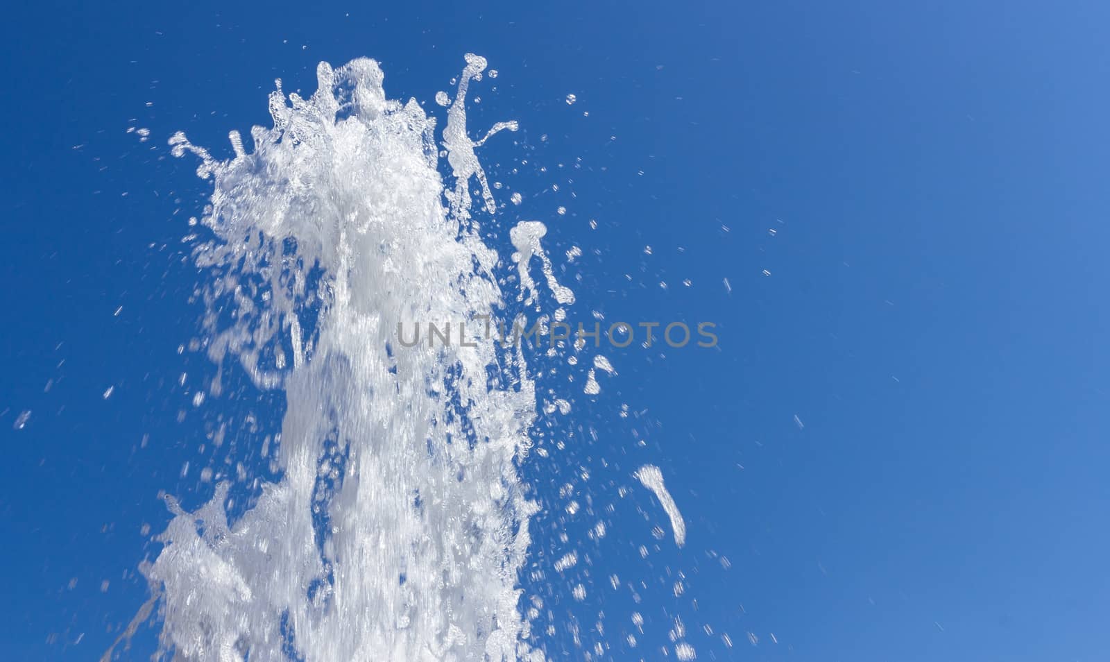 Stream of water from fountain against the blue sky