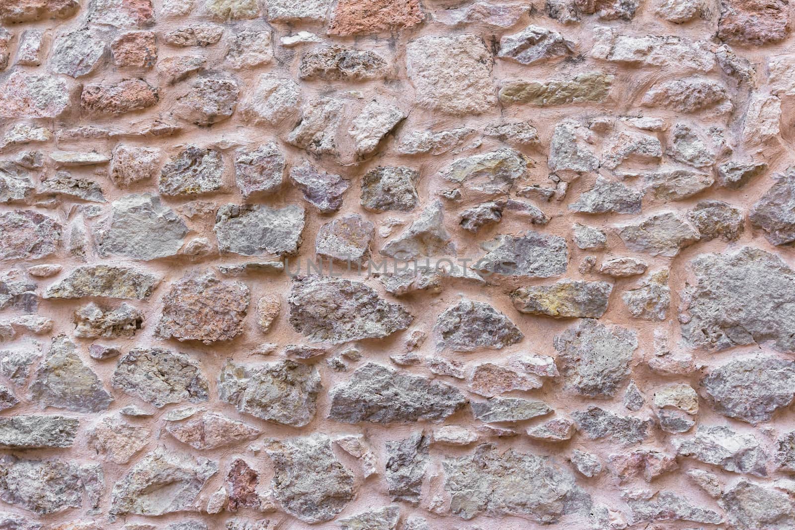 Ancient wall multicolor with irregular stones. It ideal for background.