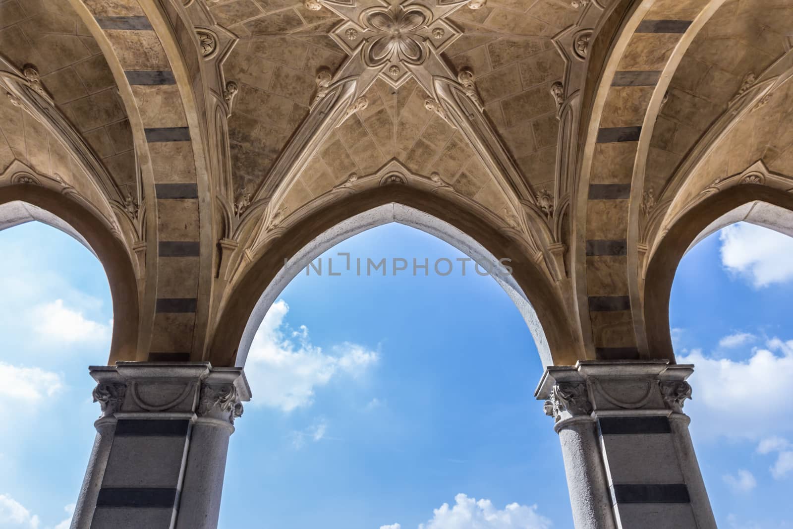 Ancient covered arcade on blue sky background