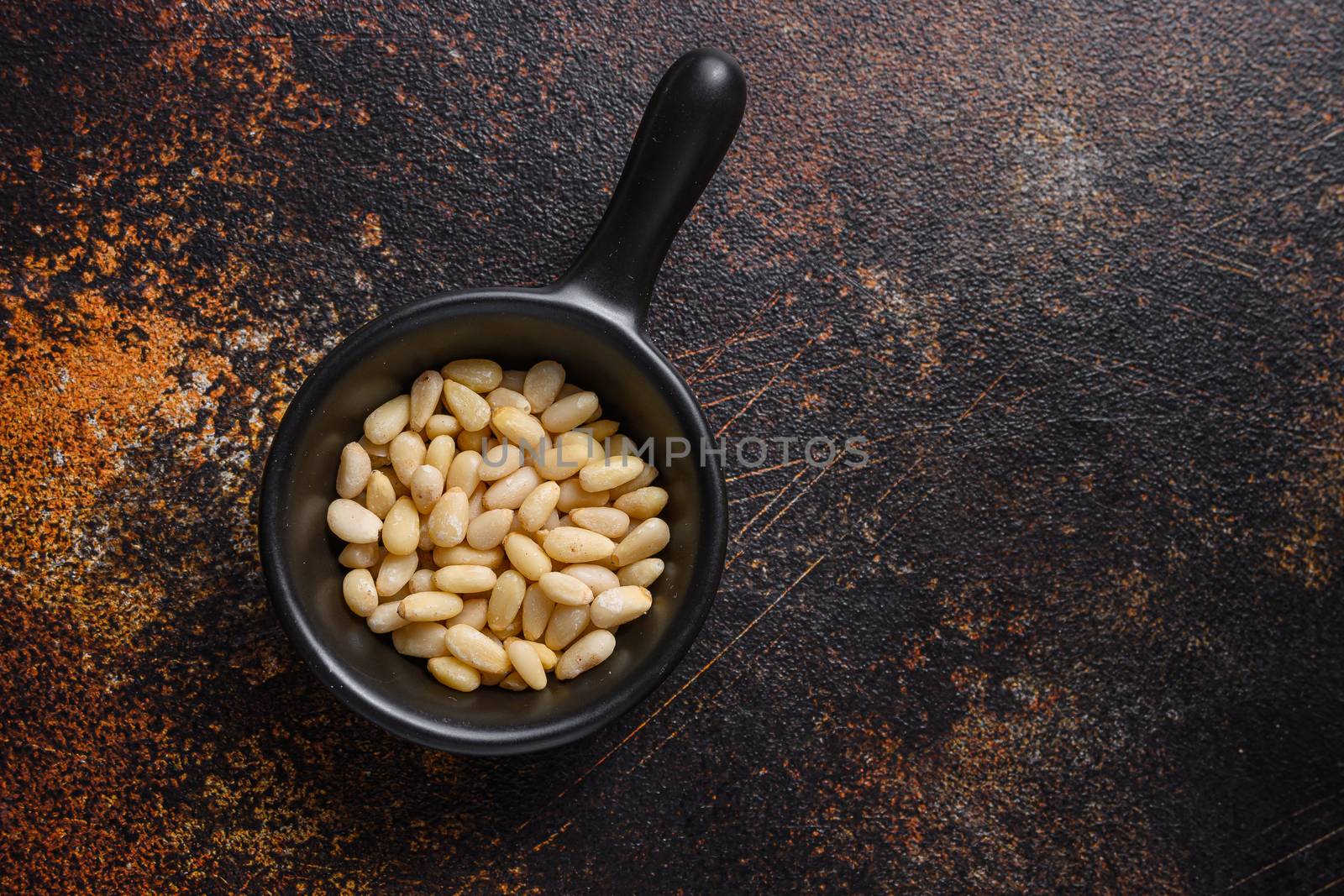 Pinenut nuts in black bowl top view space for text