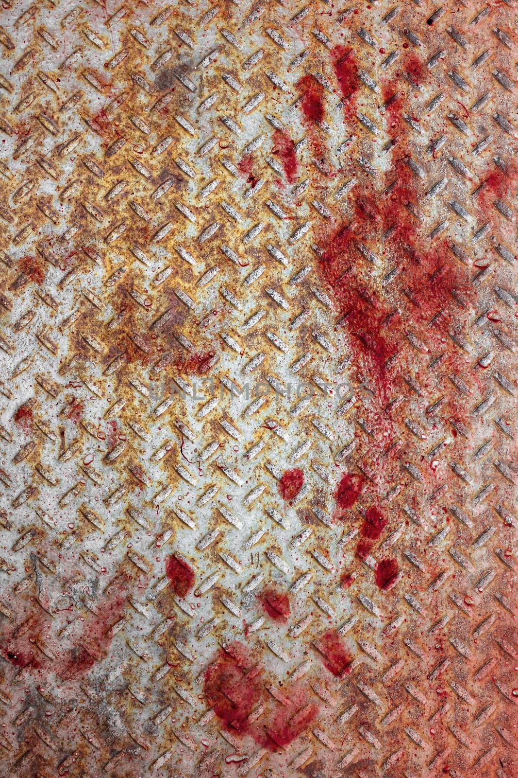 Bloody handprints and blotches of blood on rusty metal plate. Background for spooky content, halloween and more.