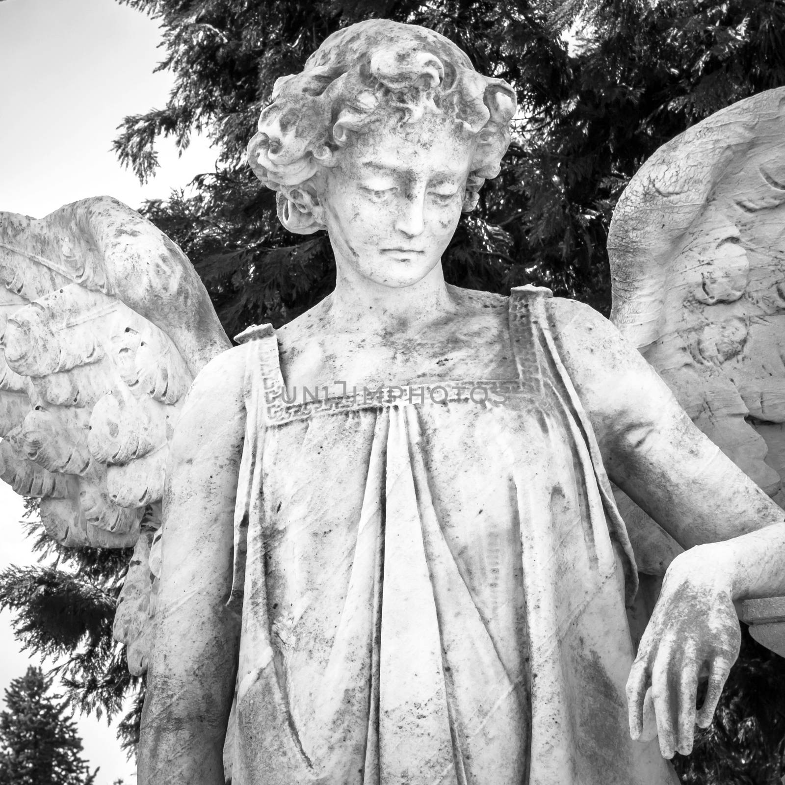 Vintage image of a sad angel on a cemetery as a symbol of love, kindness, and suffering