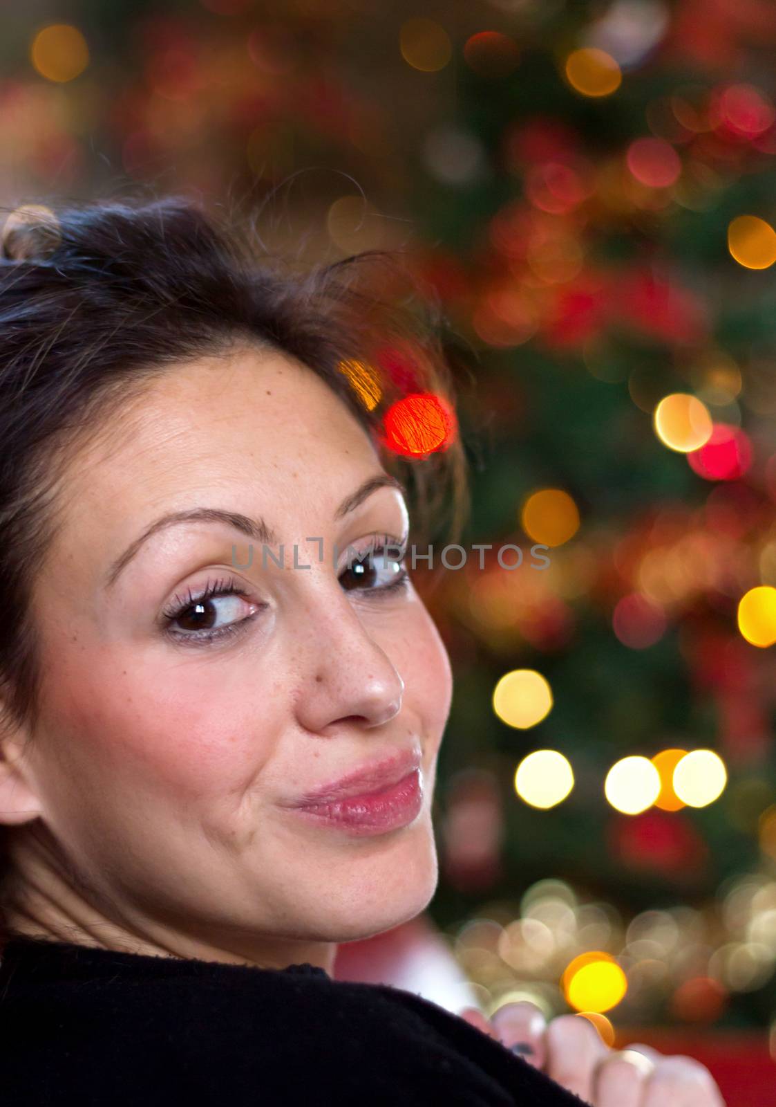 Portrait of beautiful young girl with long hair on a christmas background with boke lights. Defocused blurry background.