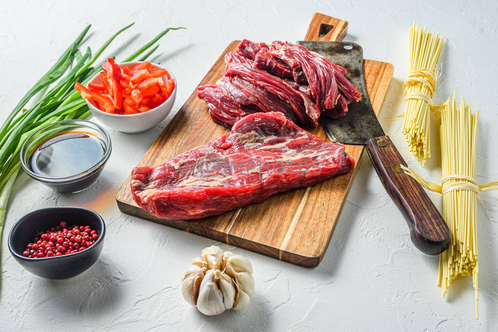 Asian food cooking - rice noodles with beef steak and noodles on white table side view