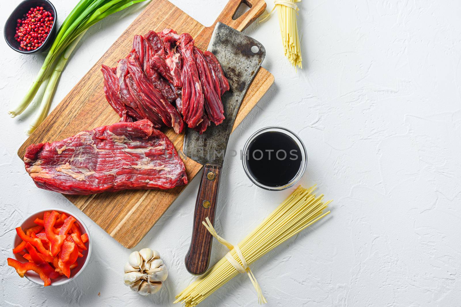 Cooking ingredients for making stir-fried yakisoba with beef. Top view on white table with space for text