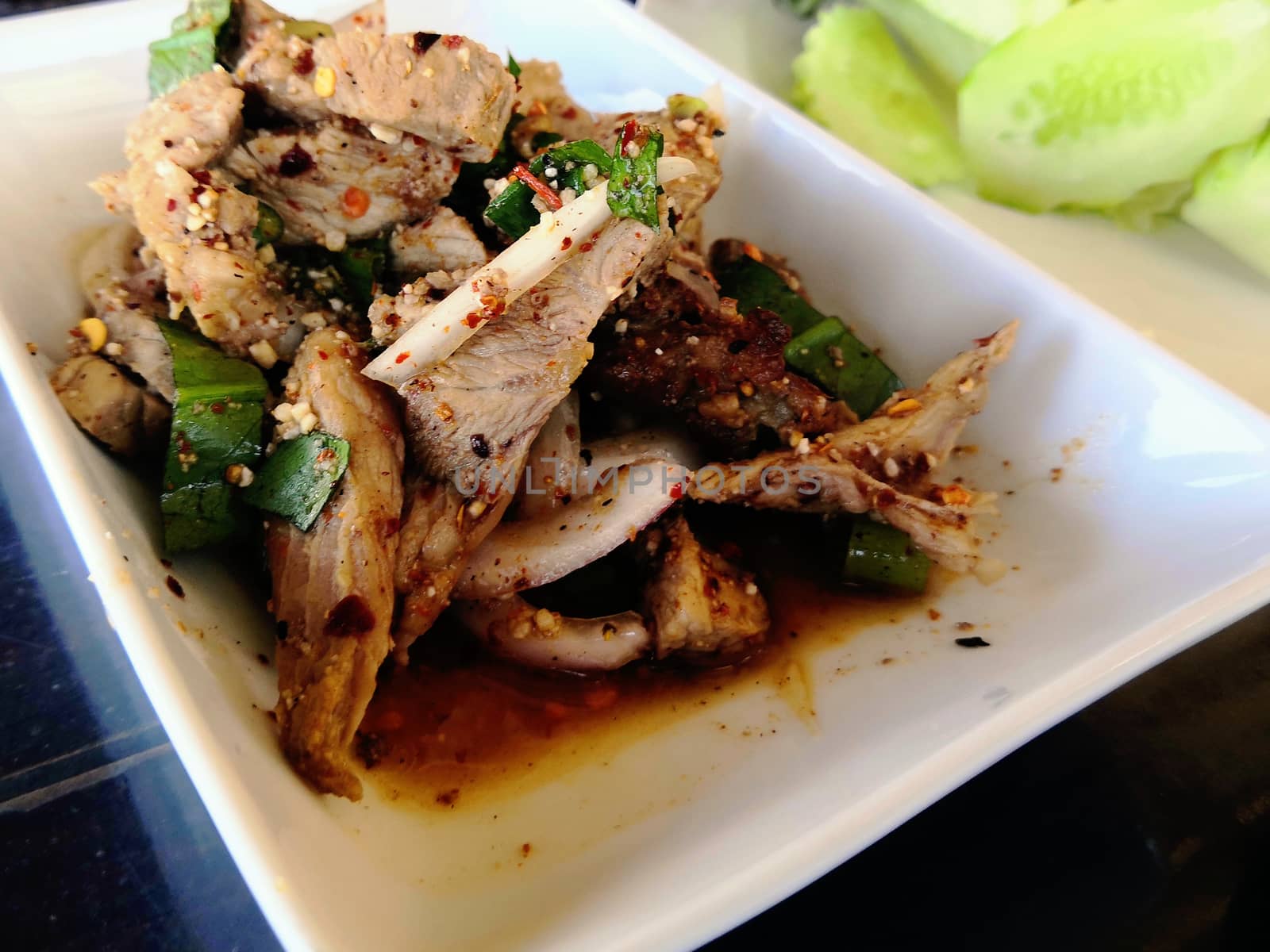 Grilled pork spicy salad on white plate