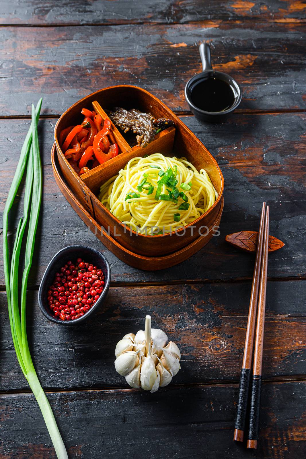 Homemade Bento pack lunch, grilled beef and noodles with ingredients side view dark wooden table by Ilianesolenyi