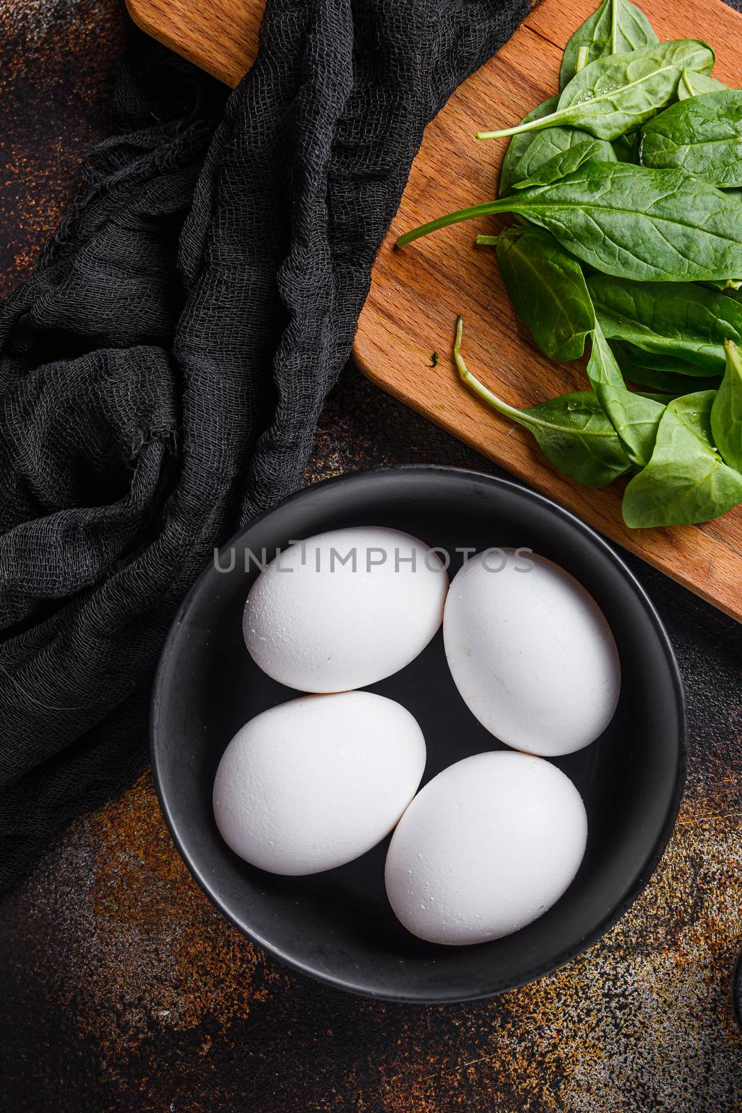 Chicken white eggs in black bowl top view. by Ilianesolenyi