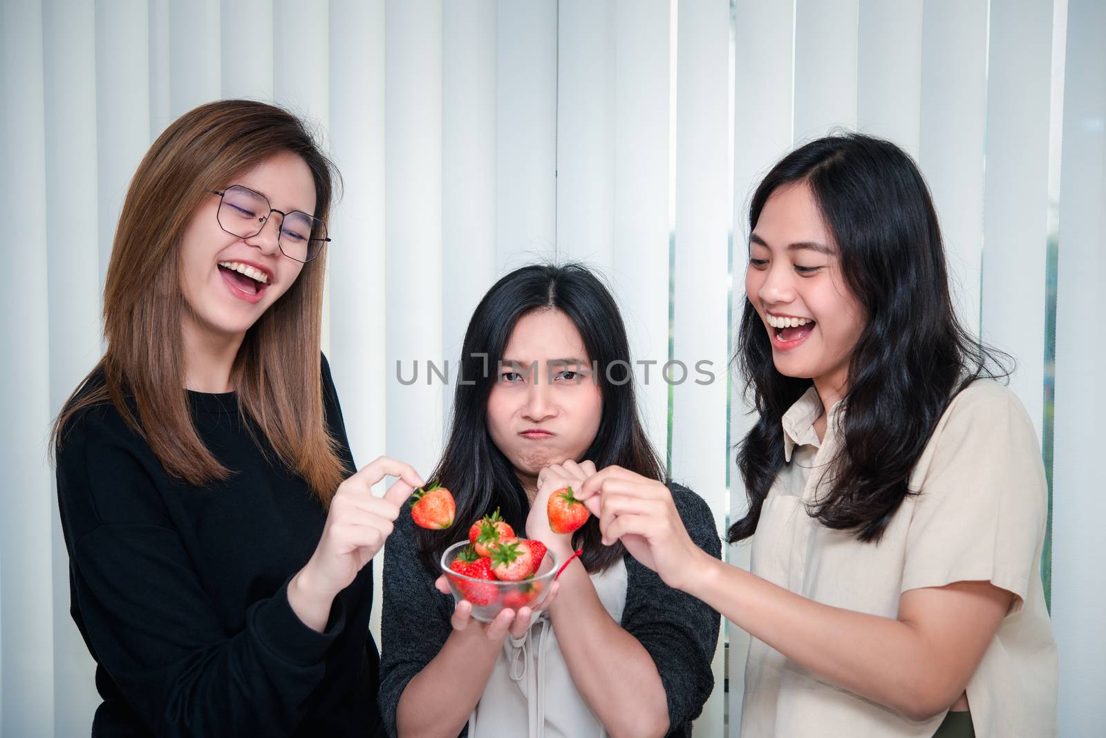 Asian pretty women holding and eating fresh strawberry is red berry fruit color and sweet juicy with enjoy and happy emotion in concept food, healthy eating in life