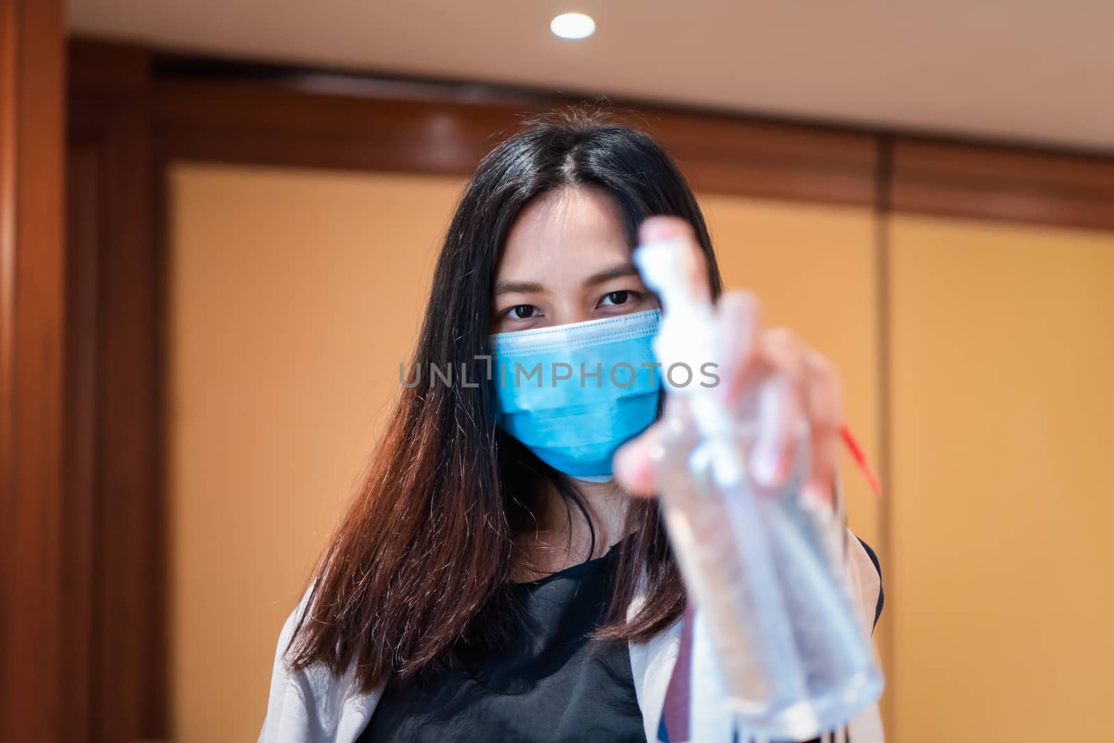 Asian woman wearing mask and alcohol antibacterial hand gel respiratory protection mask against epidemic flu covid19 or corona virus with fear emotion in concept illness, outbreak, healthcare in life