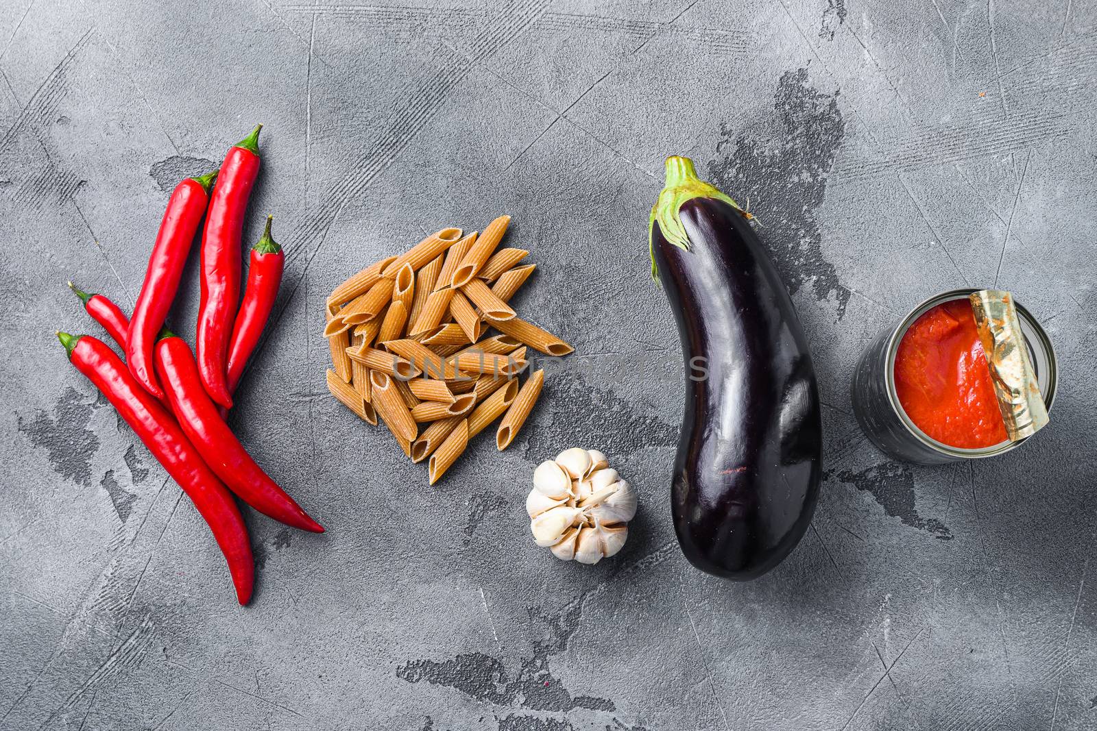 Aubergine penne ingredients eggplant pasta, pepper tomatoe sauce, on grey background top view