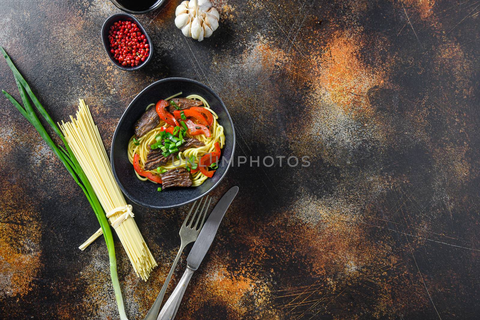 Wok with noodles and stir fry beef top view space for text