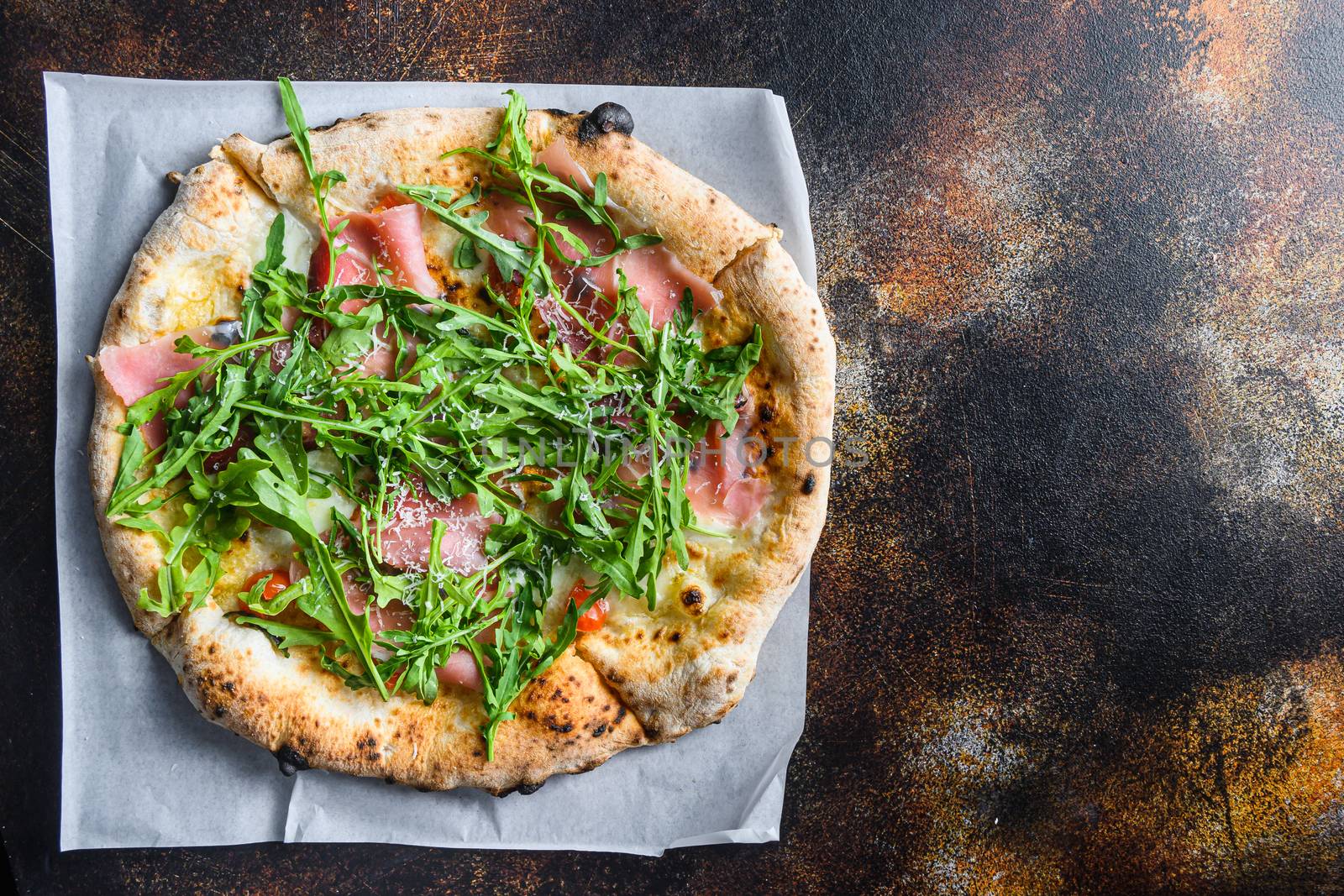 Italian pizza with mozzarella, cheese and basil leaves on old surface.