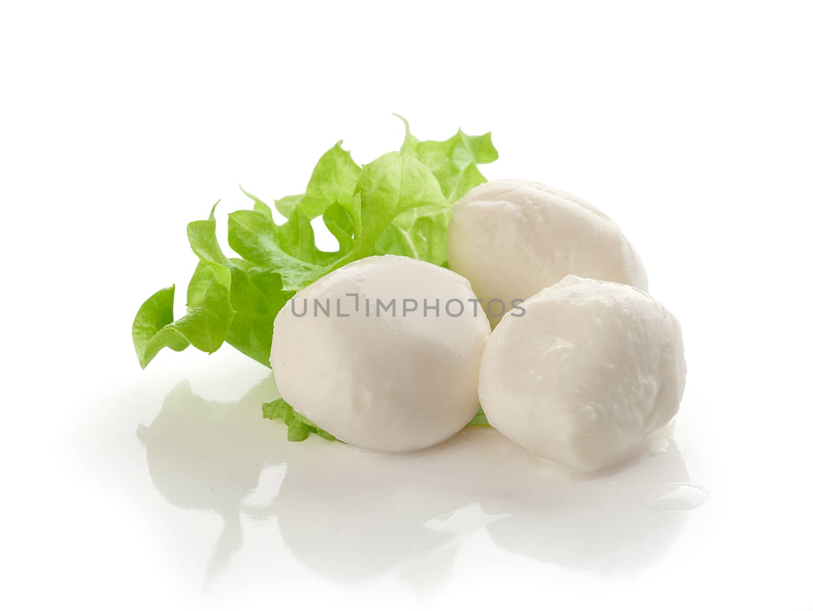 Three small balls of mozzarella with fresh green leaf of lettuce