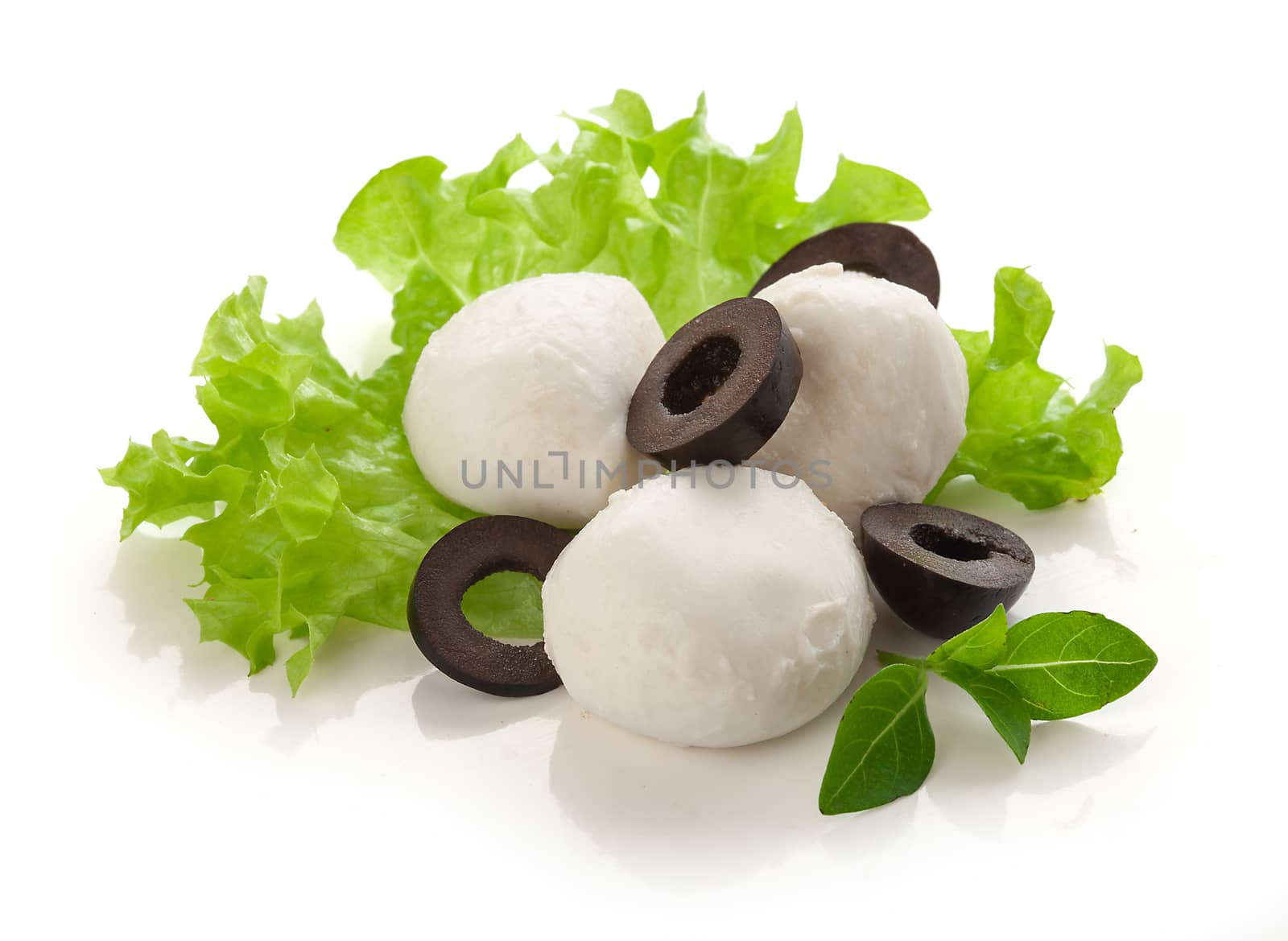 Some small balls of mozzarella with black olives and fresh green lettuce