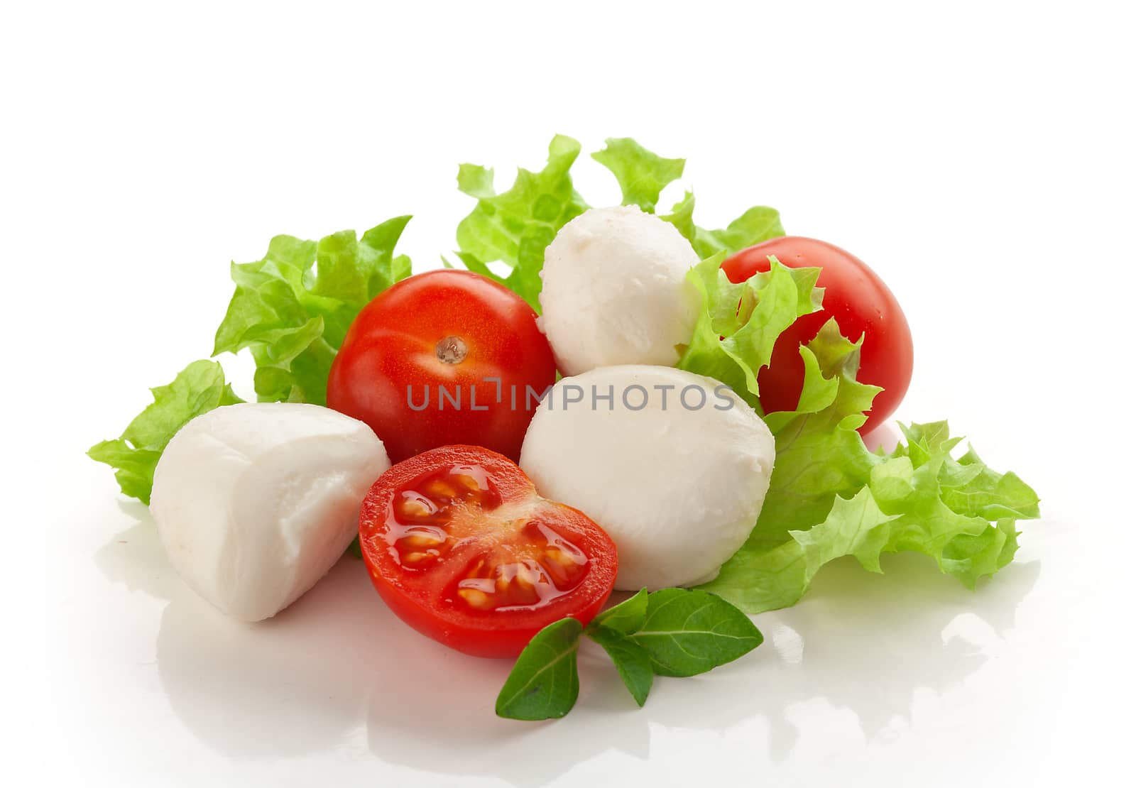 Small balls of Mozzarella with tomato cherry and fresh green lettuce