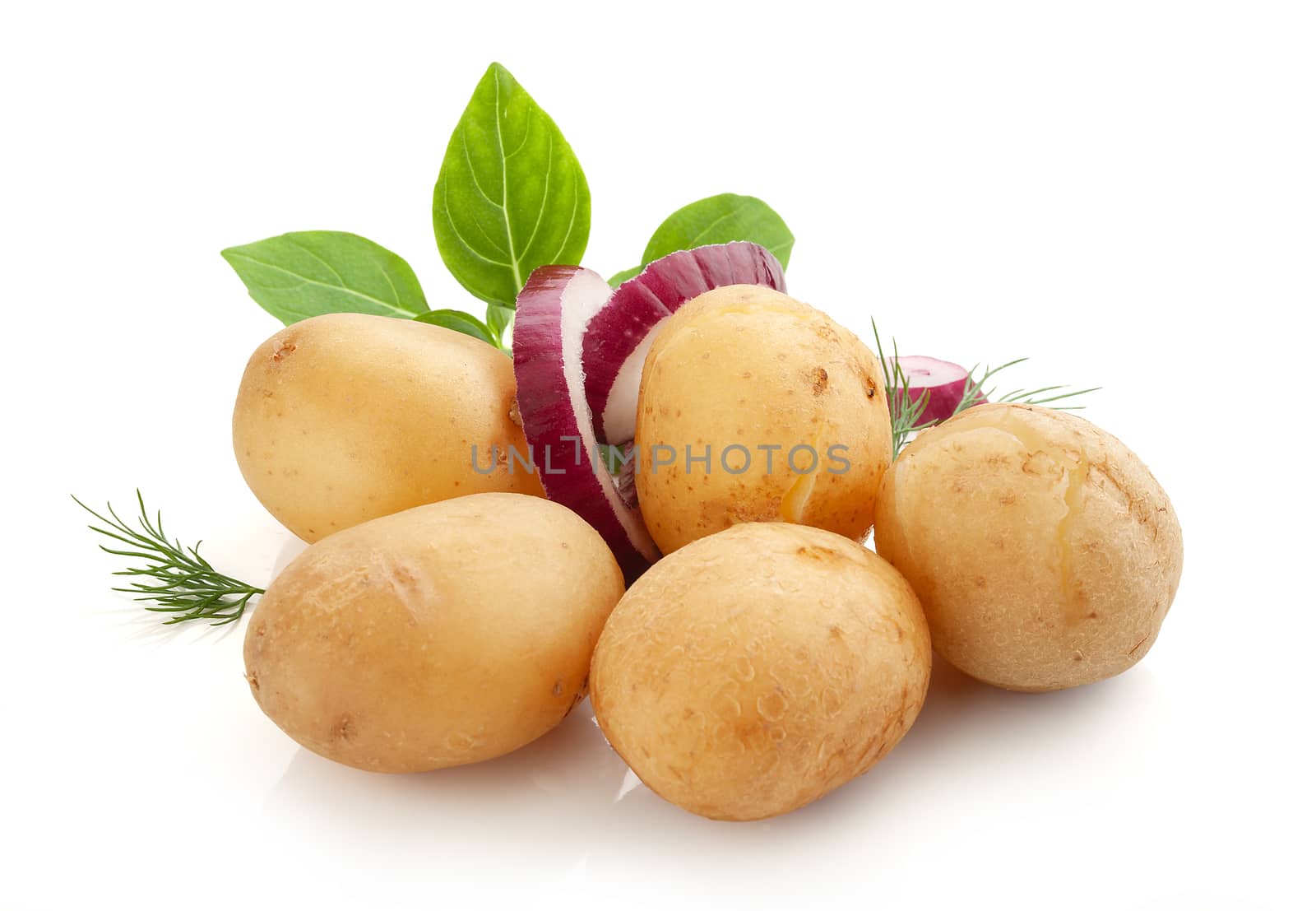 Isolated heap of jacket potatoes with basil leaves, dill and red onion