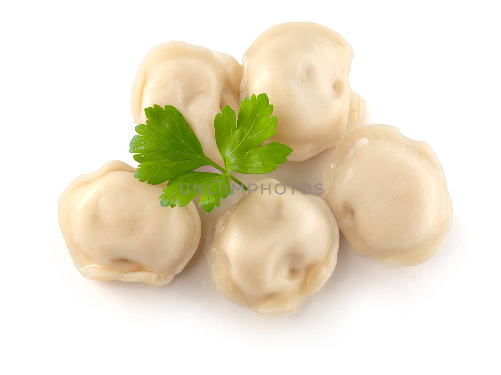 Handful of boiled dumplings with fresh parsley leaf on the white