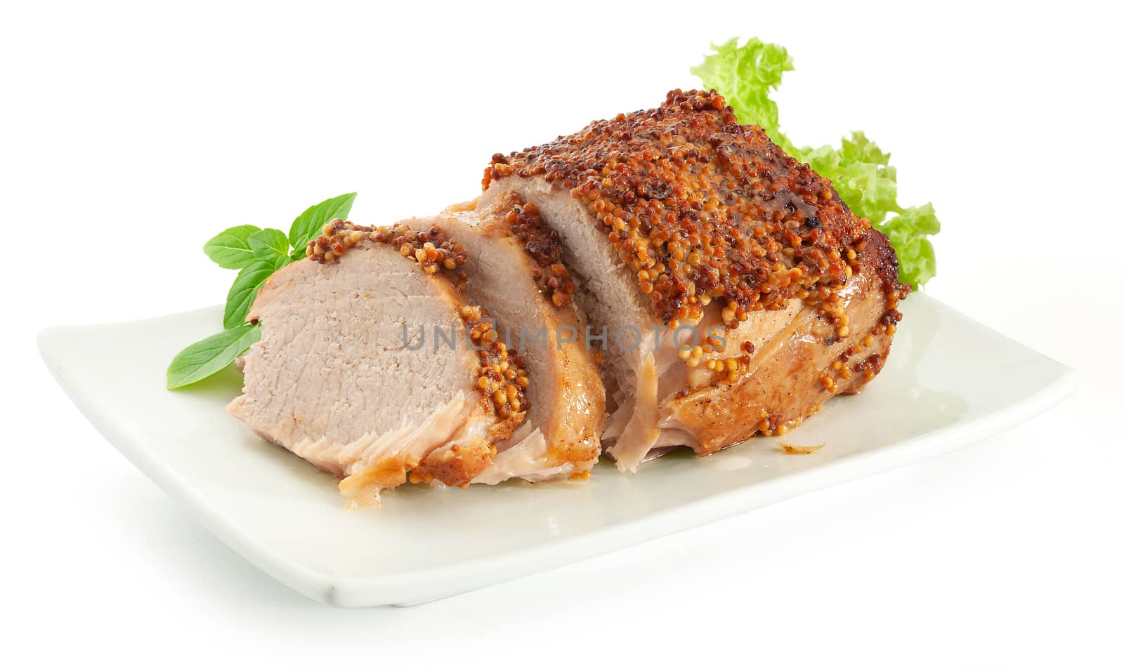 Baked pork with french mustard, basil and lettuce on the plate