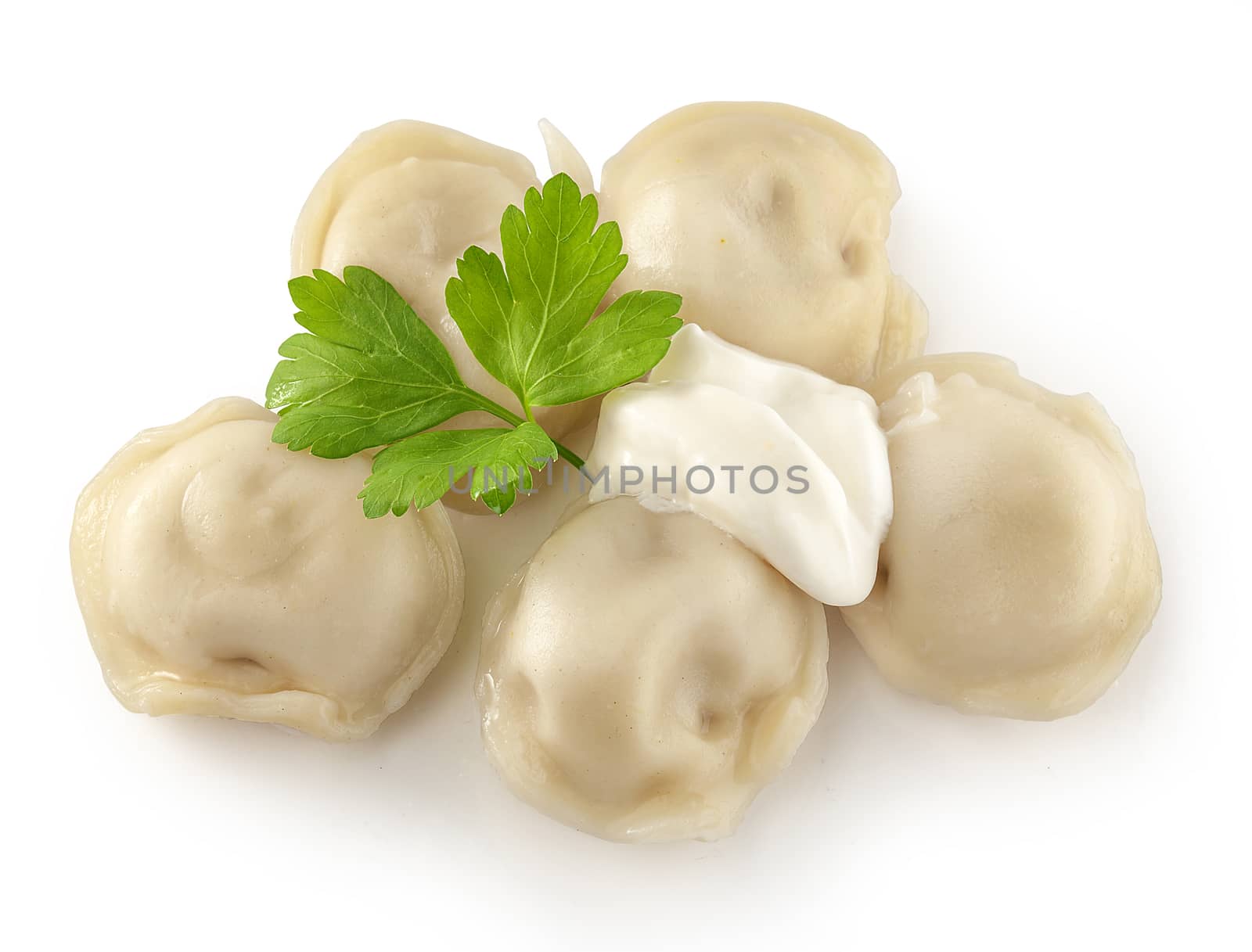 Handful of boiled dumplings with sourcream and fresh parsley leaf