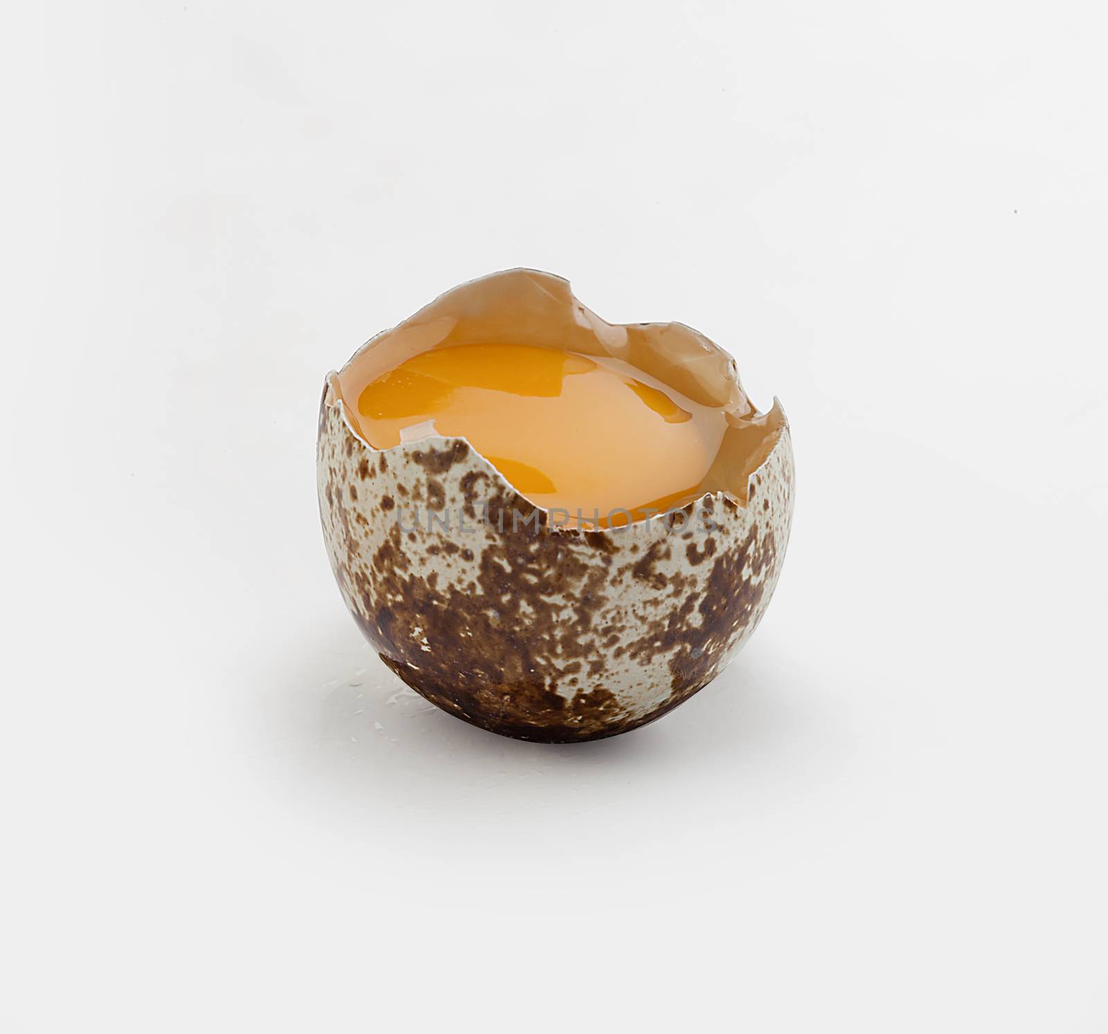 Isolated broken quail egg on the white background