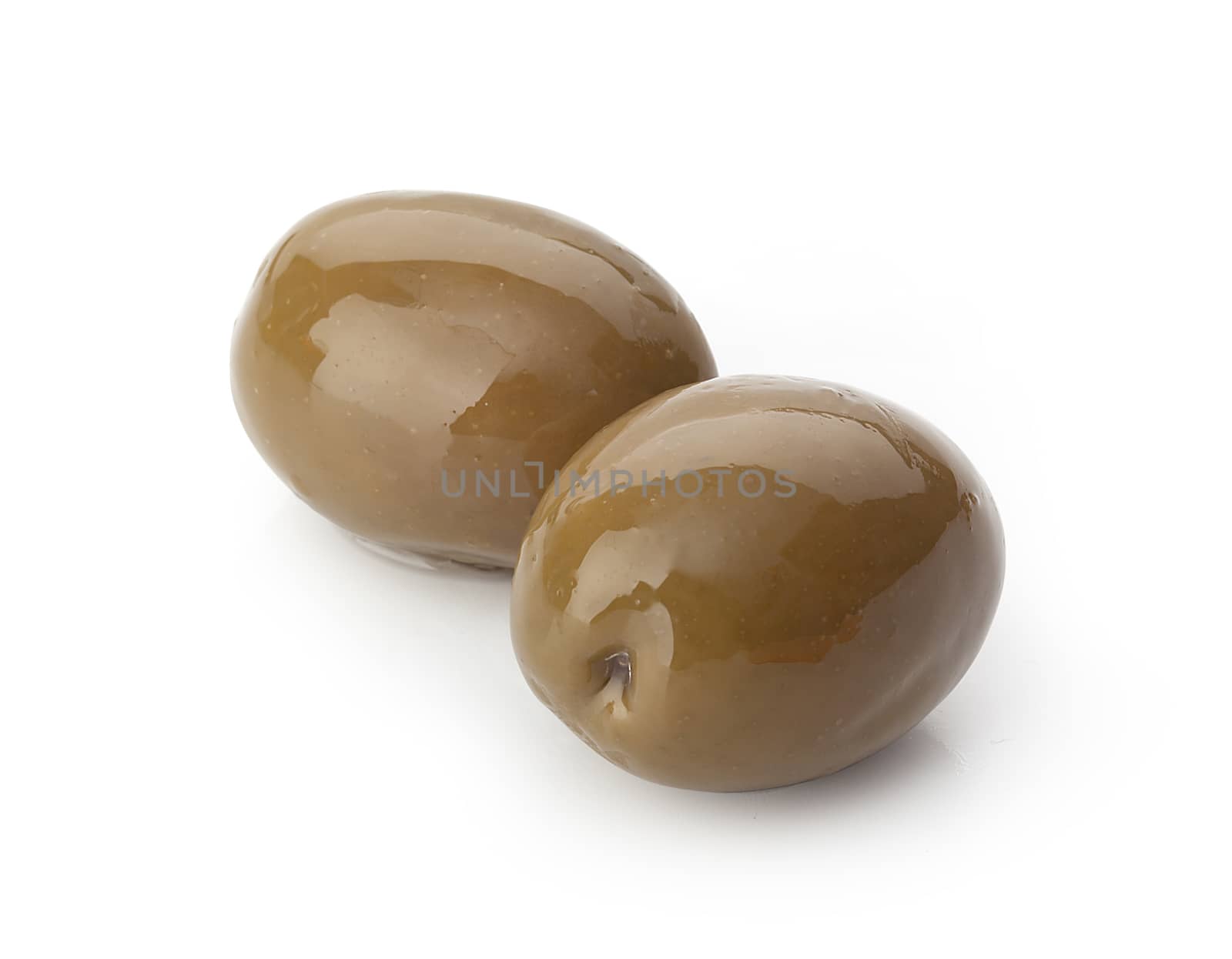 Two marinated green olives with a pit on the white background