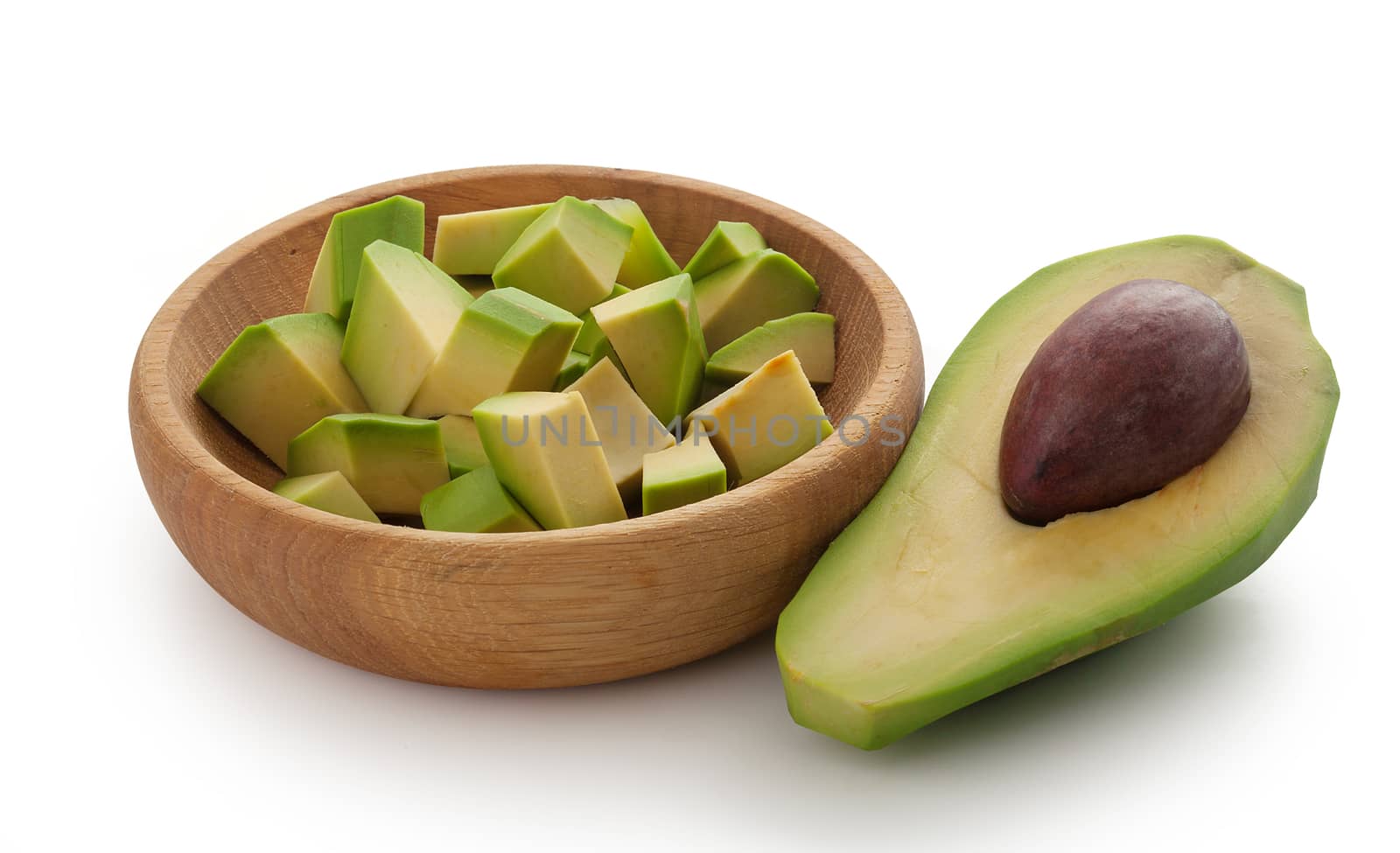 Half of avocado and avocado cubes in bowl by Angorius