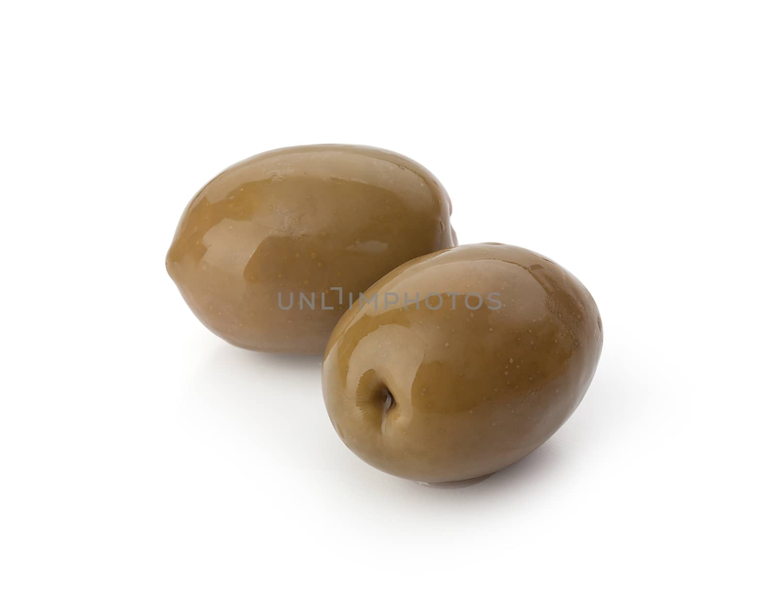 Two marinated green olives with a pit on the white background