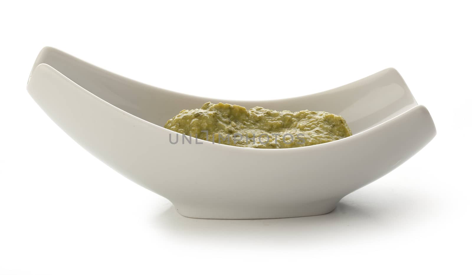 Pesto sauce in the gravy boat on the white