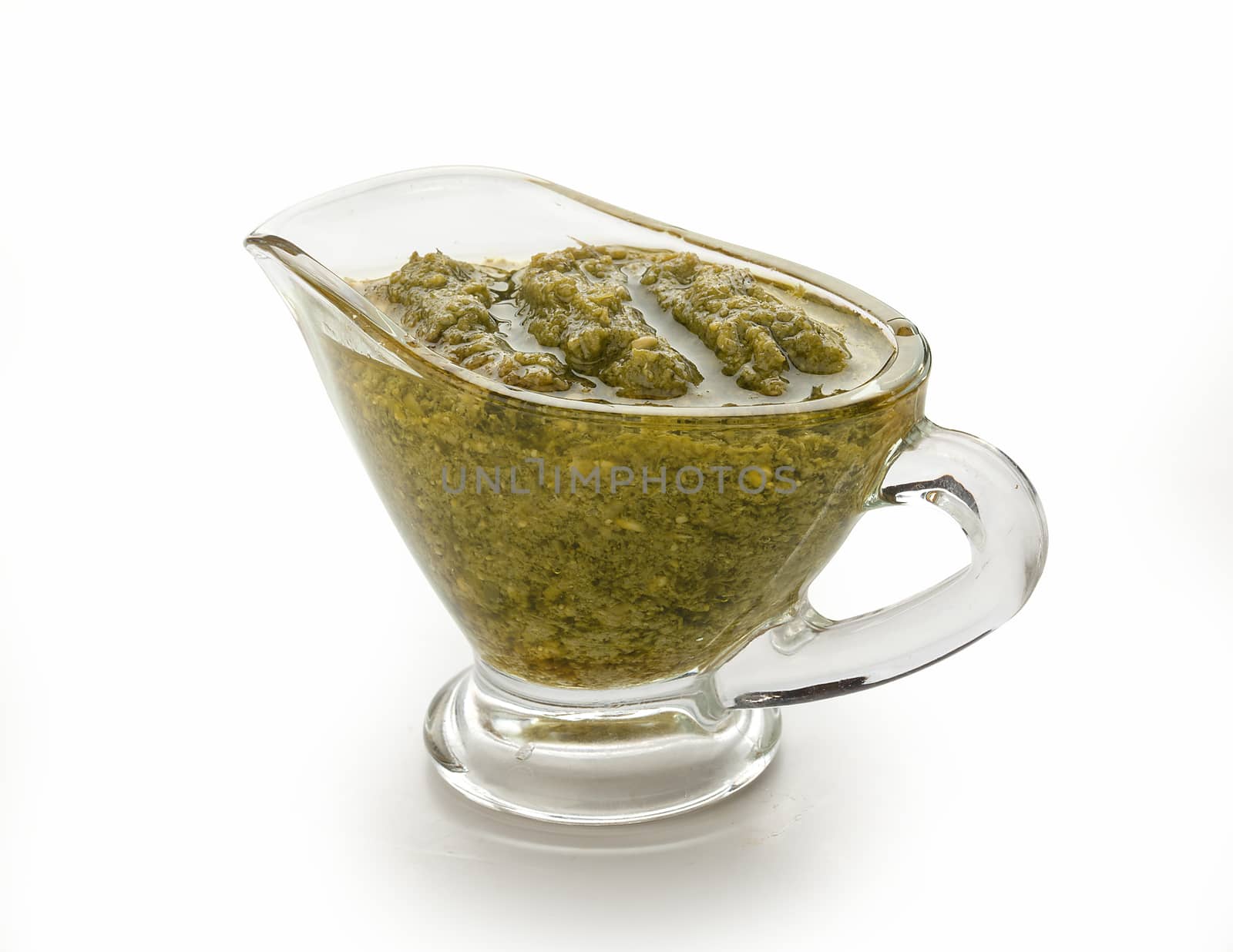 Pesto sauce in the gravy boat on the white