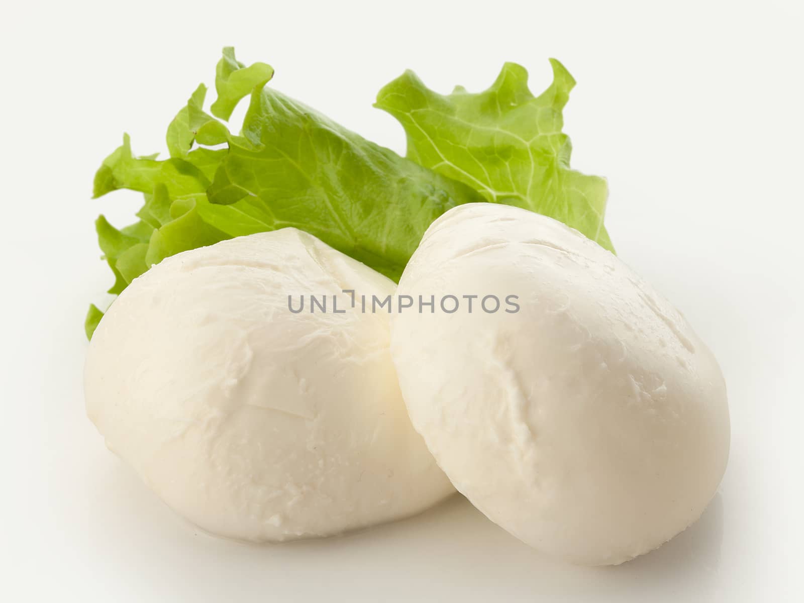 Two balls of mozzarella with fresh green lettuce