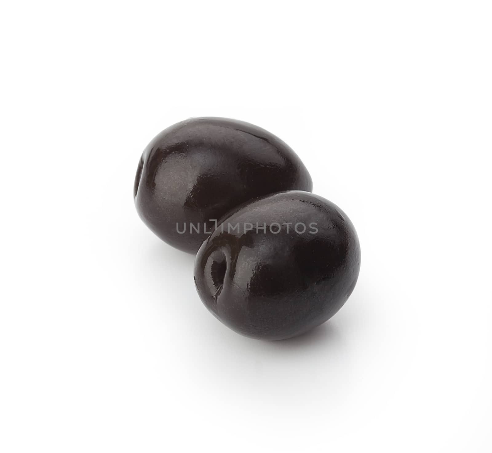 Two black olives with pit on the white background