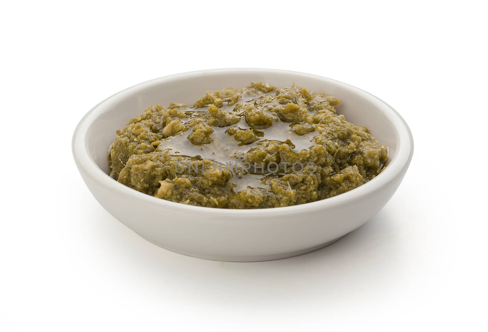 Pesto sauce in the gravy boat on the white